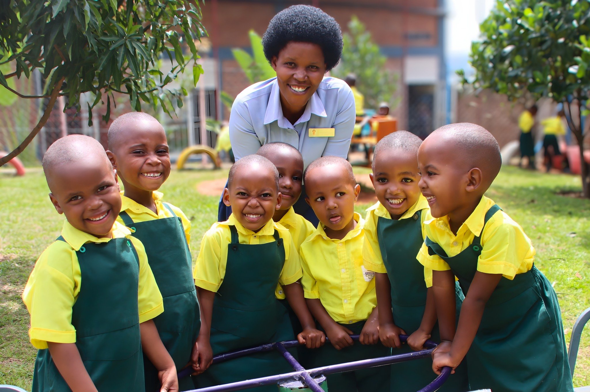 This cheerful group of Early Childhood Development students and their teacher is beginning the day with lots of fun activities on our preschool playground. As you can see from all the smiling faces, the children are ready to romp and play. May your d