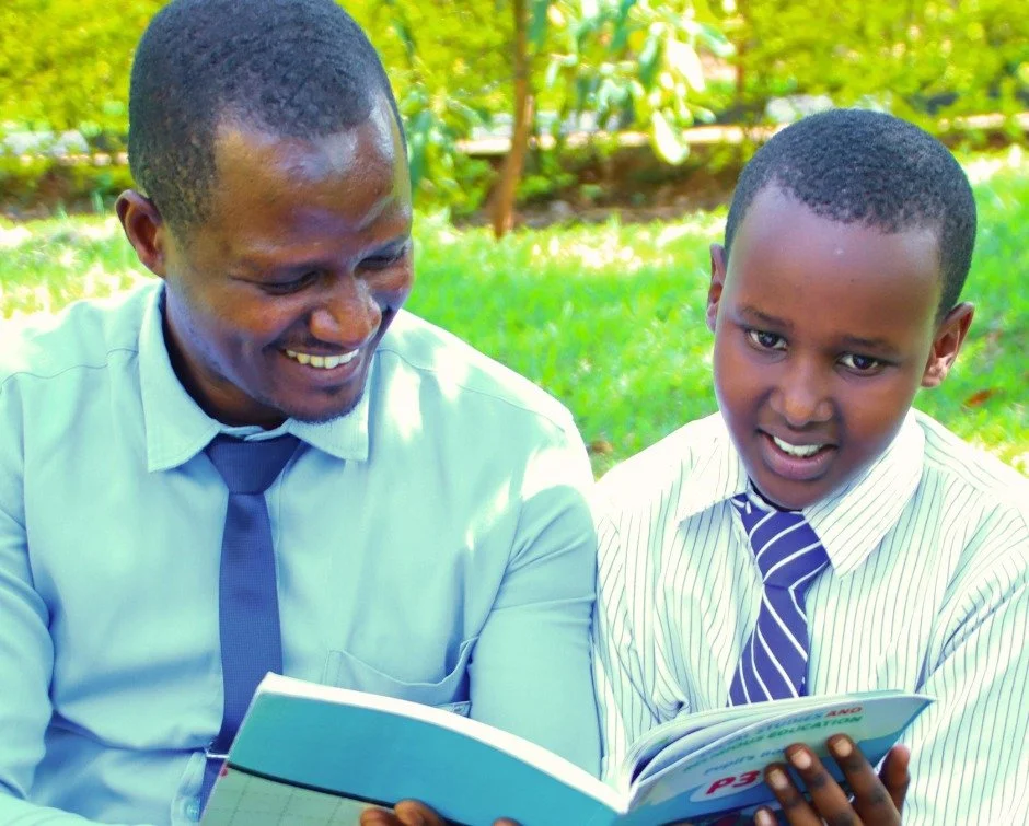 Gallia is nine years old and in Primary 4 at Rwanda Children Christian School.

This week, she sat with her teacher, Claude Kubwimana, reading together beneath the trees on campus.

A book lies open between them.

Claude is not standing in front of a