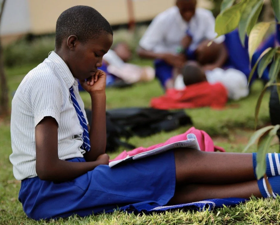 Nobody assigned these five minutes.

Classes had ended.

The walk home hadn't begun.

There was time to simply wait.

So this Rwanda Children Christian School student opened her notebook.

Moments like these remind us that education isn't simply abou
