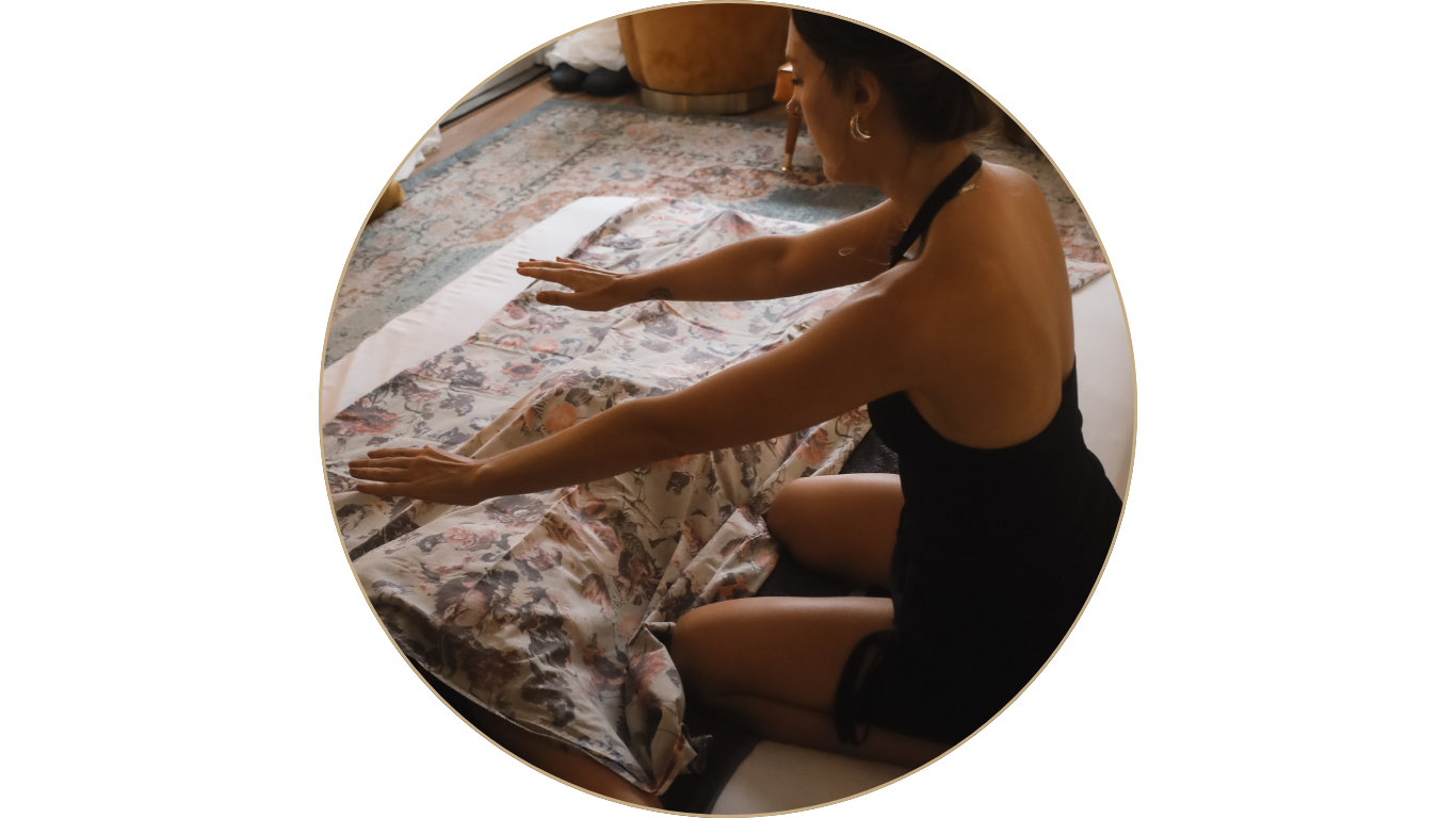 A woman giving energy work to a female client on the floor