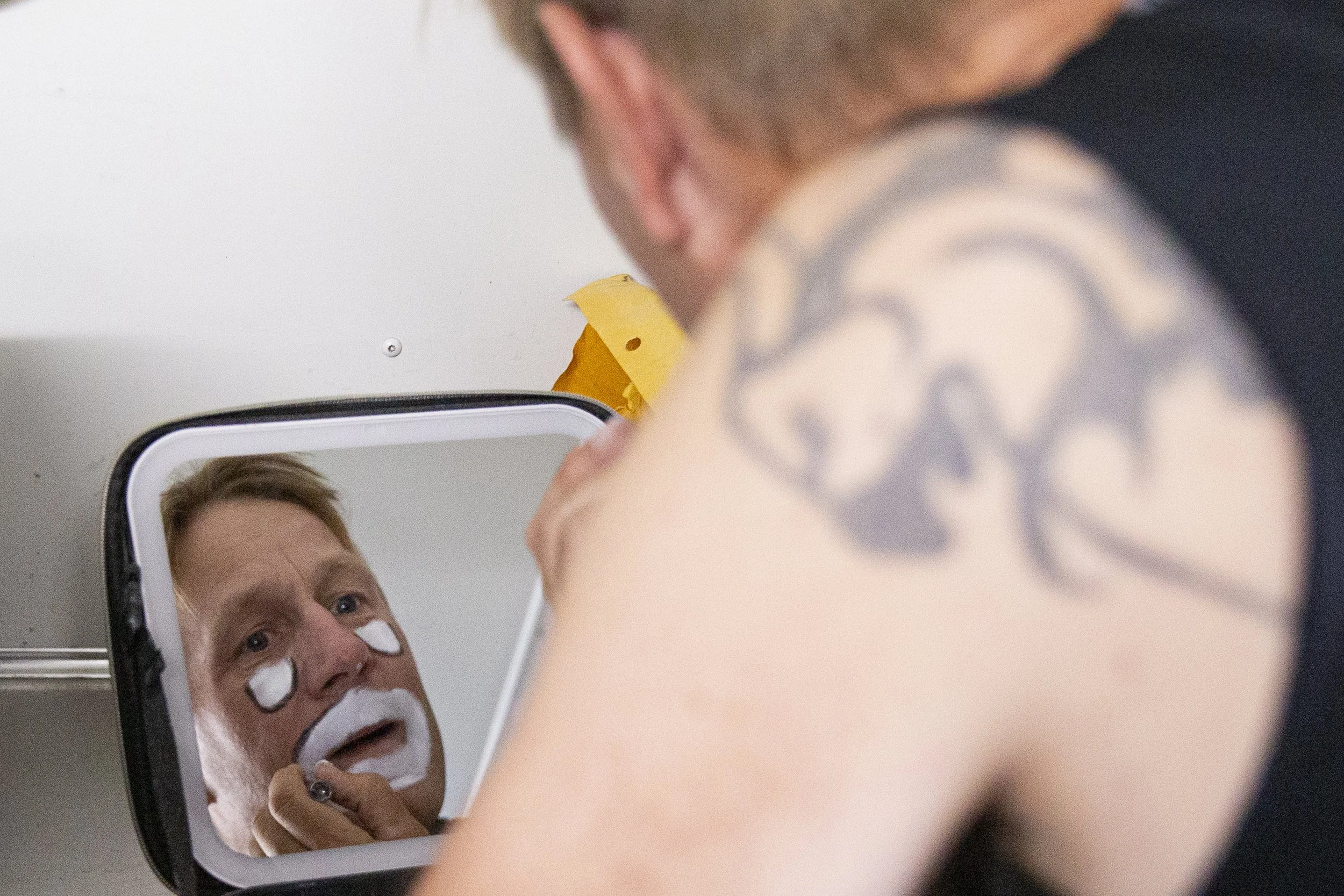 JJ Harrison applies his own clown makeup in preparation for his performance.