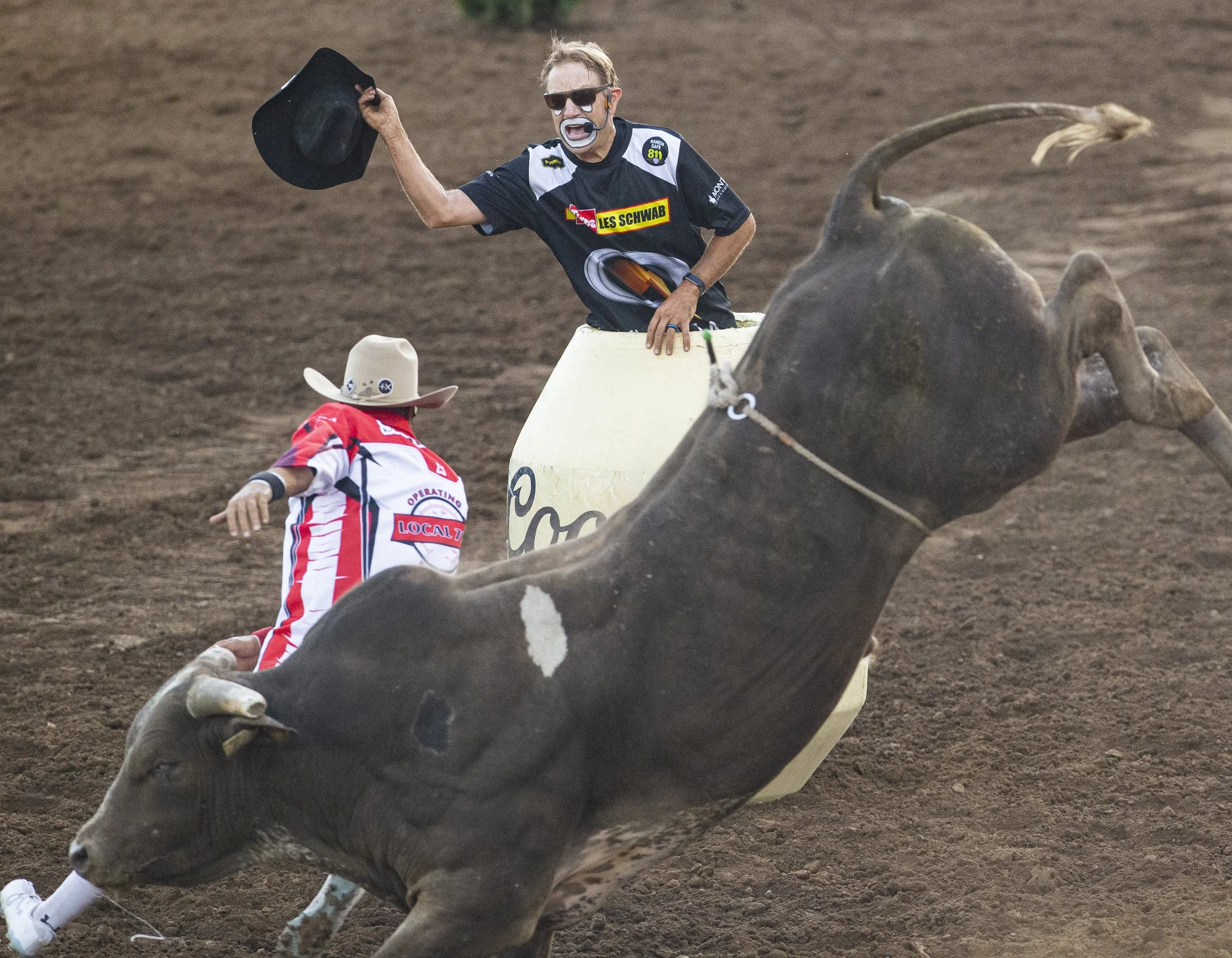 JJ Harrison attempts to draw a bull’s attention from other rodeo clowns inside the arena.