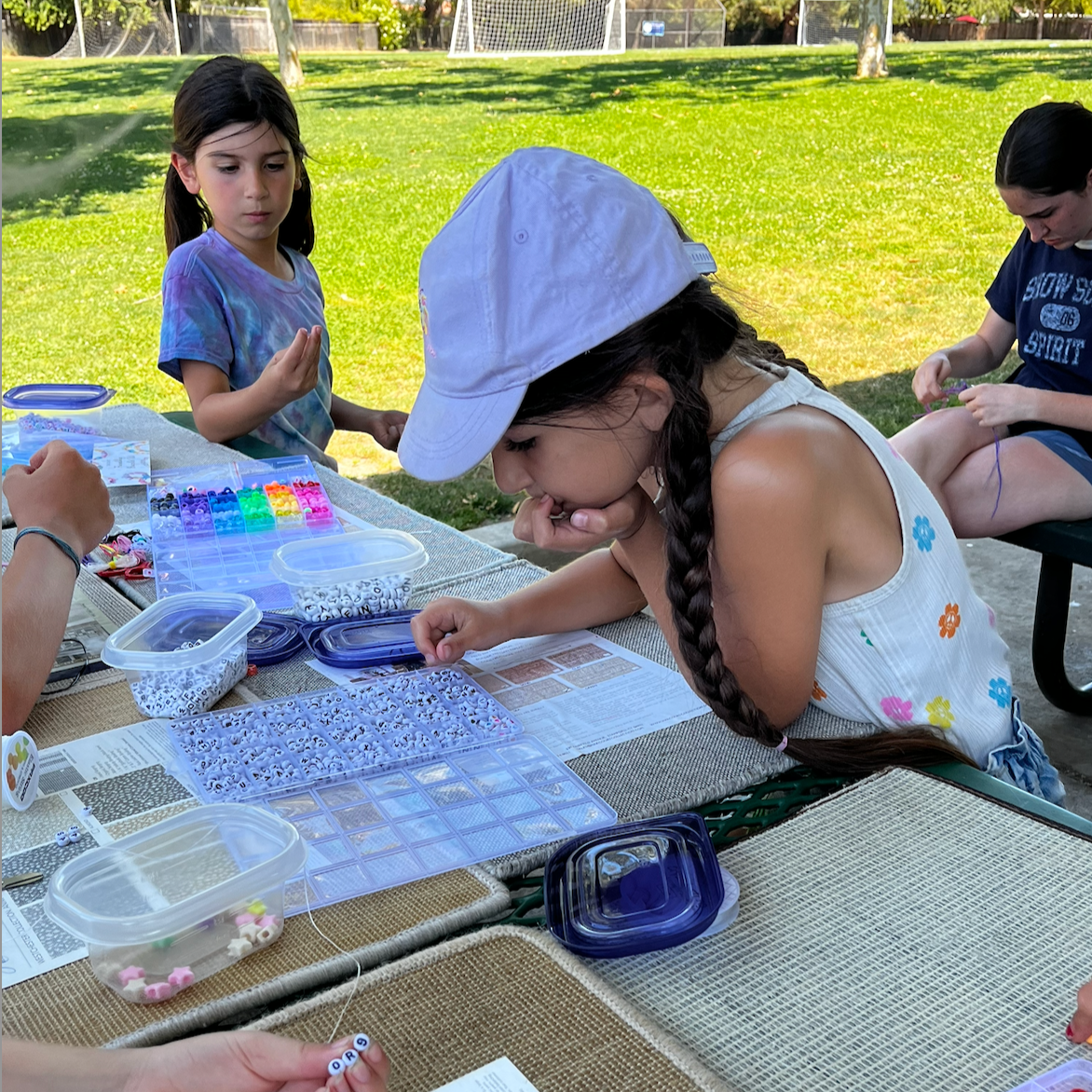 Overtime Sports Camp Camper making bracelets in Los Gatos, California. Bay Area Summer Sports Camp.