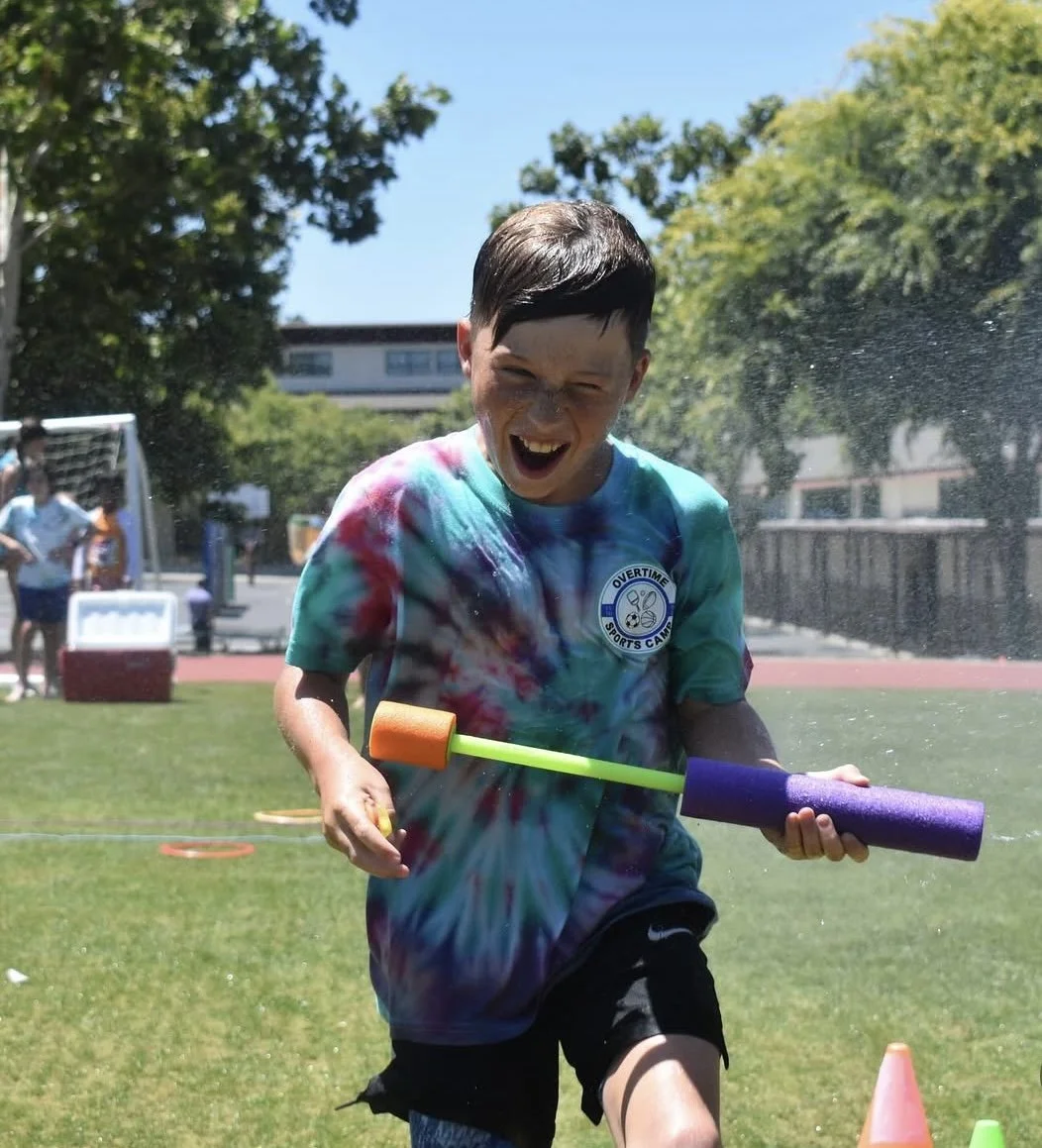 Summer Camp Camper Playing in a Water Fight