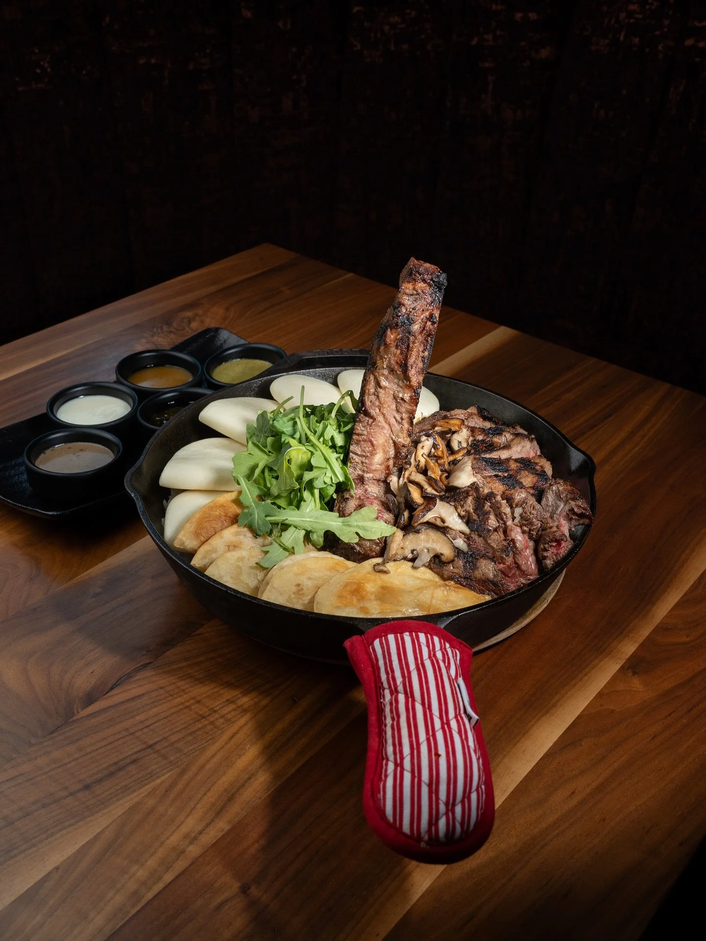 🍴The Porterhouse Table Feast 🥩
A 32oz porterhouse steak, served over a bed of sushi rice and paired with bao buns, tortillas, and shiitake mushrooms. Accompanied by house-made sauces &mdash; foie gras, chimichurri, garlic aioli, cilantro lime sauce