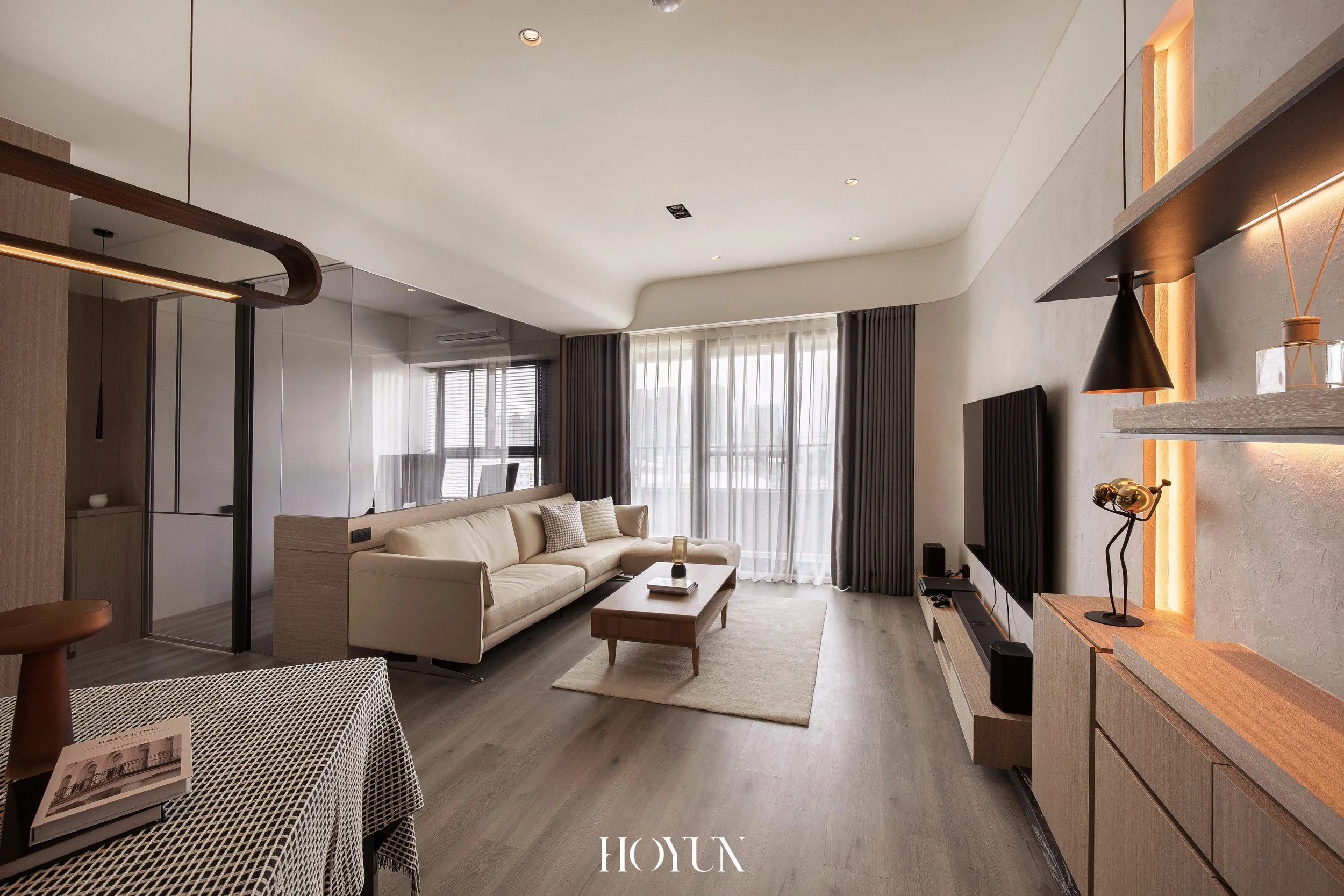 客廳全景，低彩度牆面與木質地坪，光帶勾勒層次