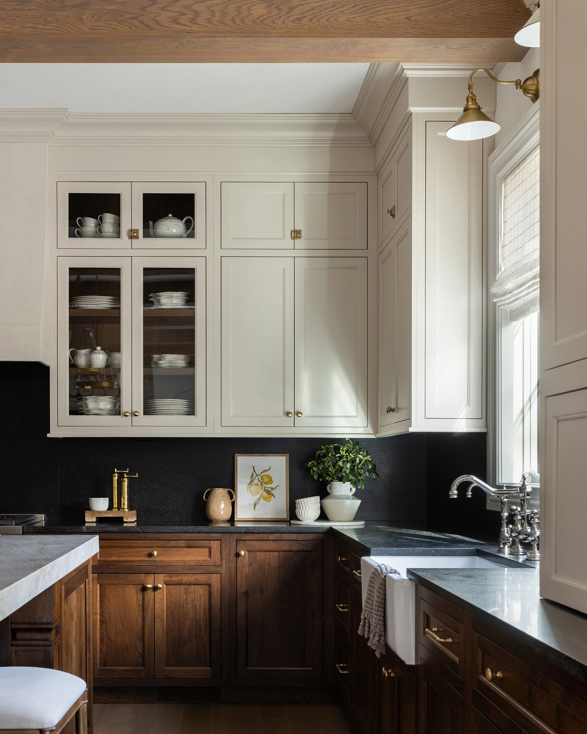 White kitchen with dark wood island and glass cabinets by Raquel Langworthy