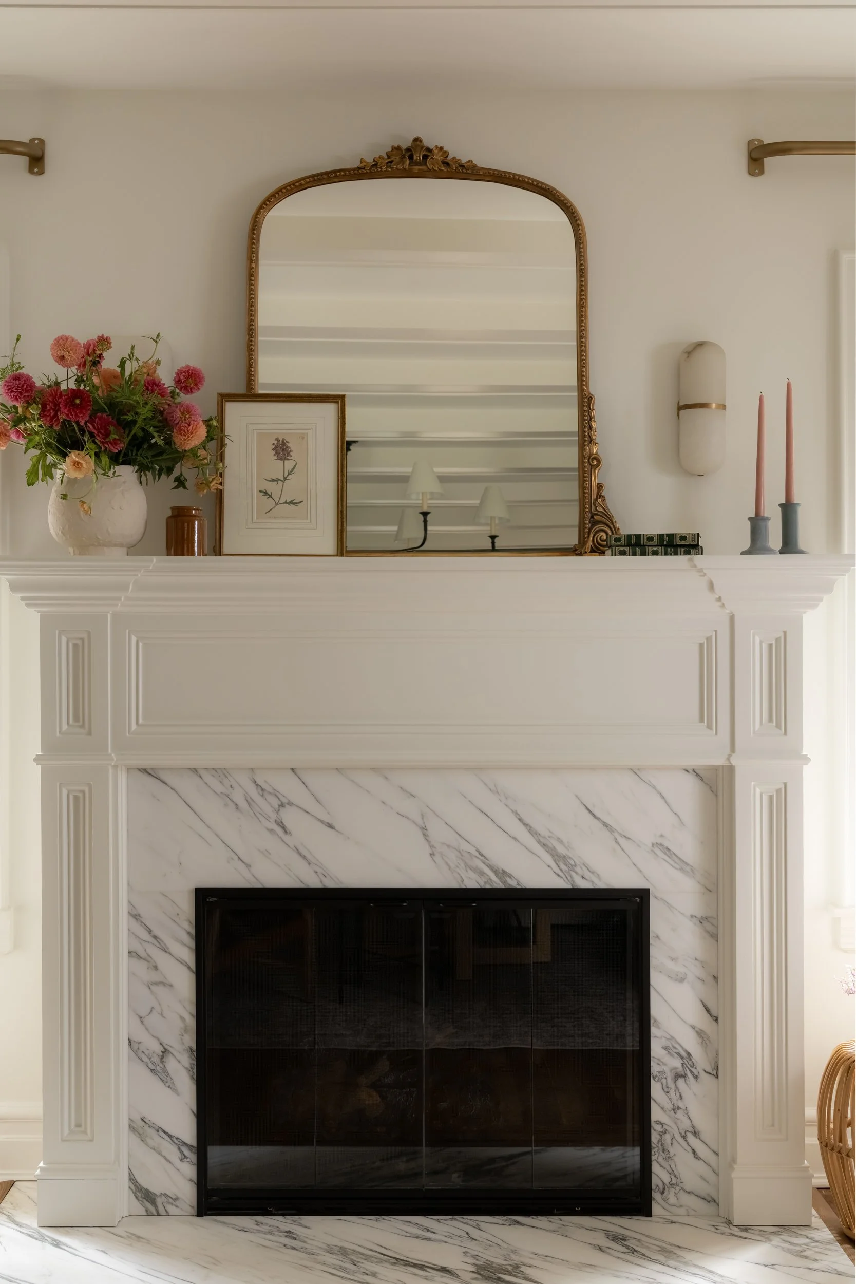 Bedroom corner with round mirror and floral arrangement by Raquel Langworthy