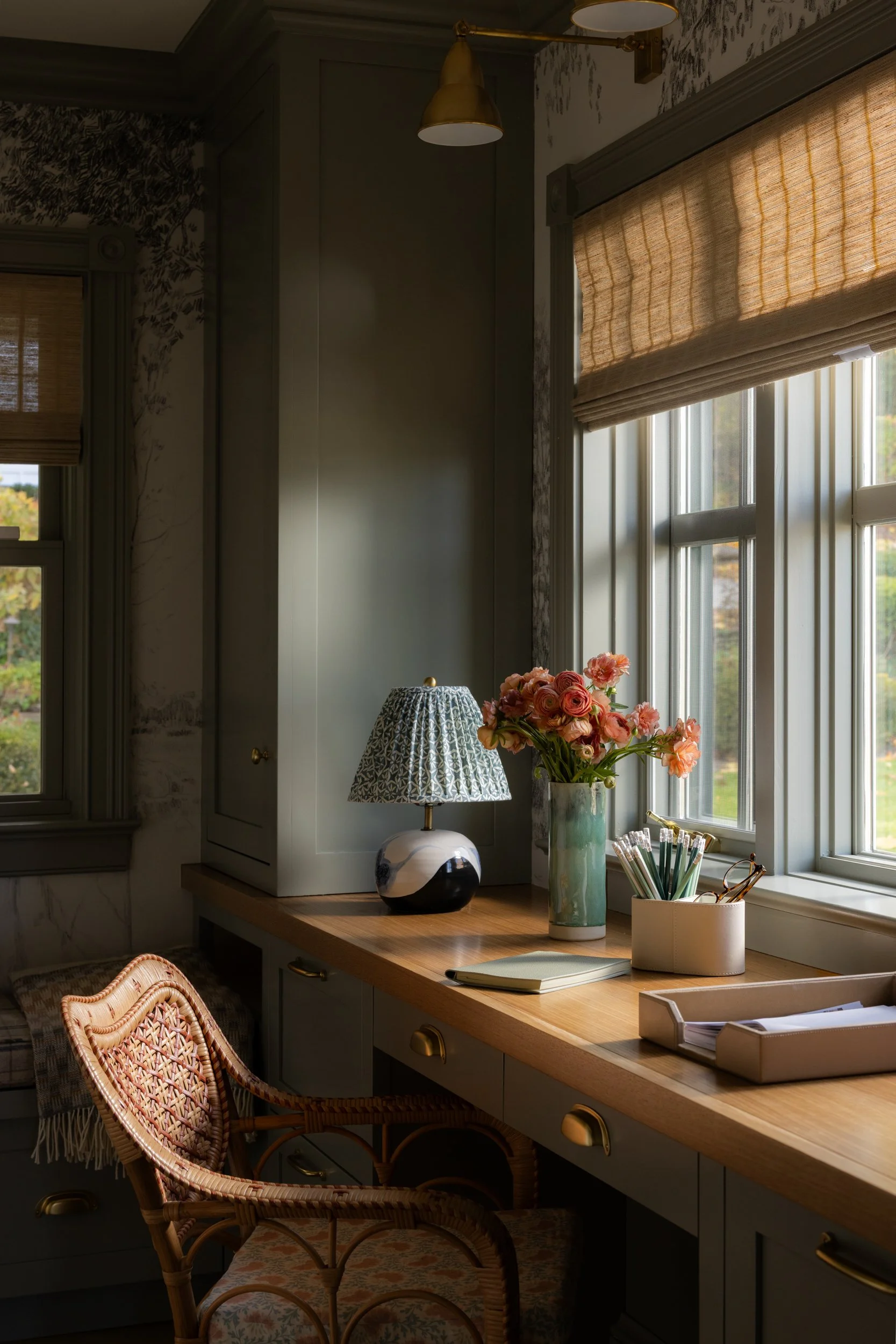 A moody office desk vignette featuring dramatic lighting and high-contrast shadows from a nearby window, featured in The Wall Street Journal. Photographed by Raquel Langworthy.