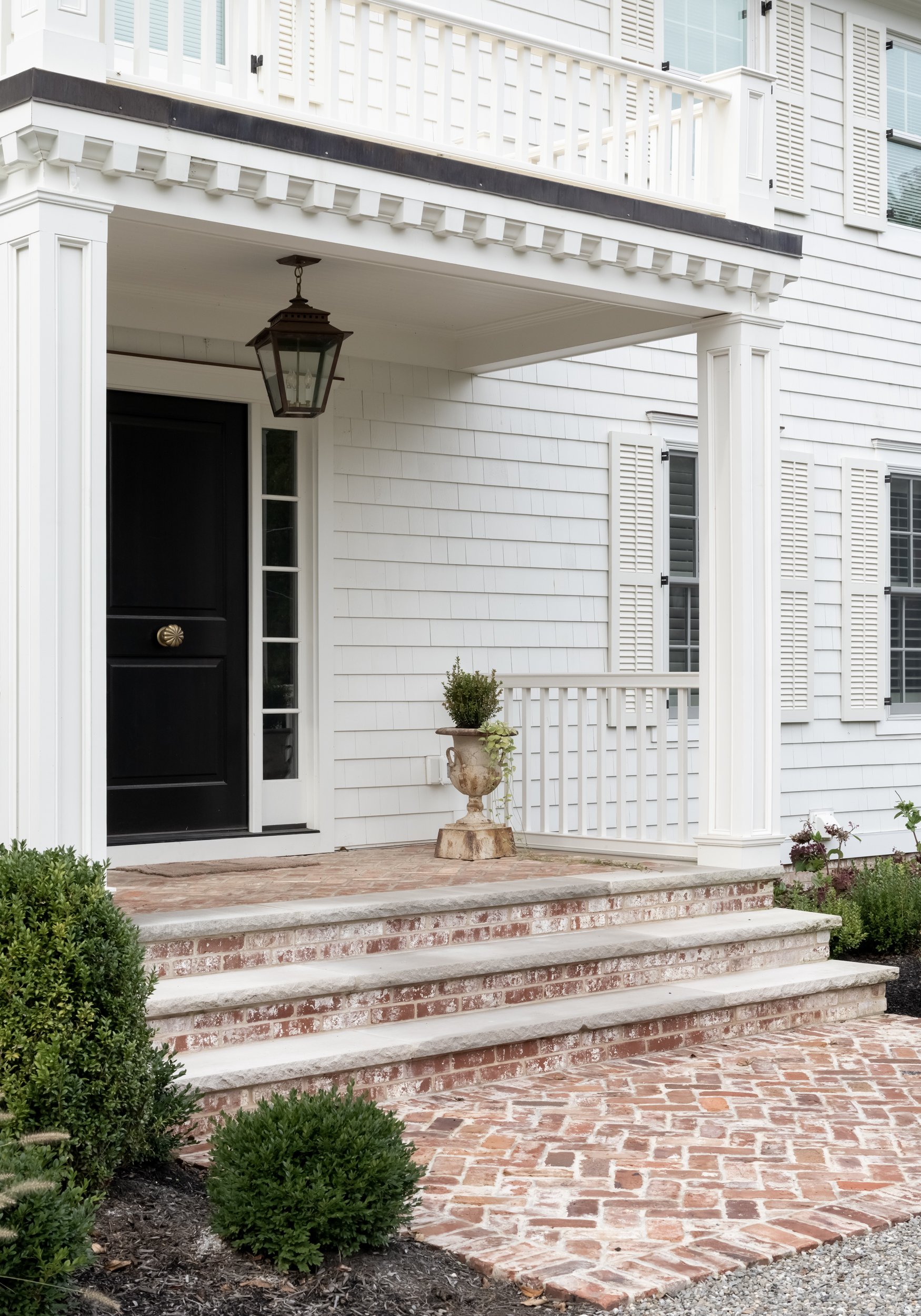 White house front door with brick steps by Raquel Langworthy