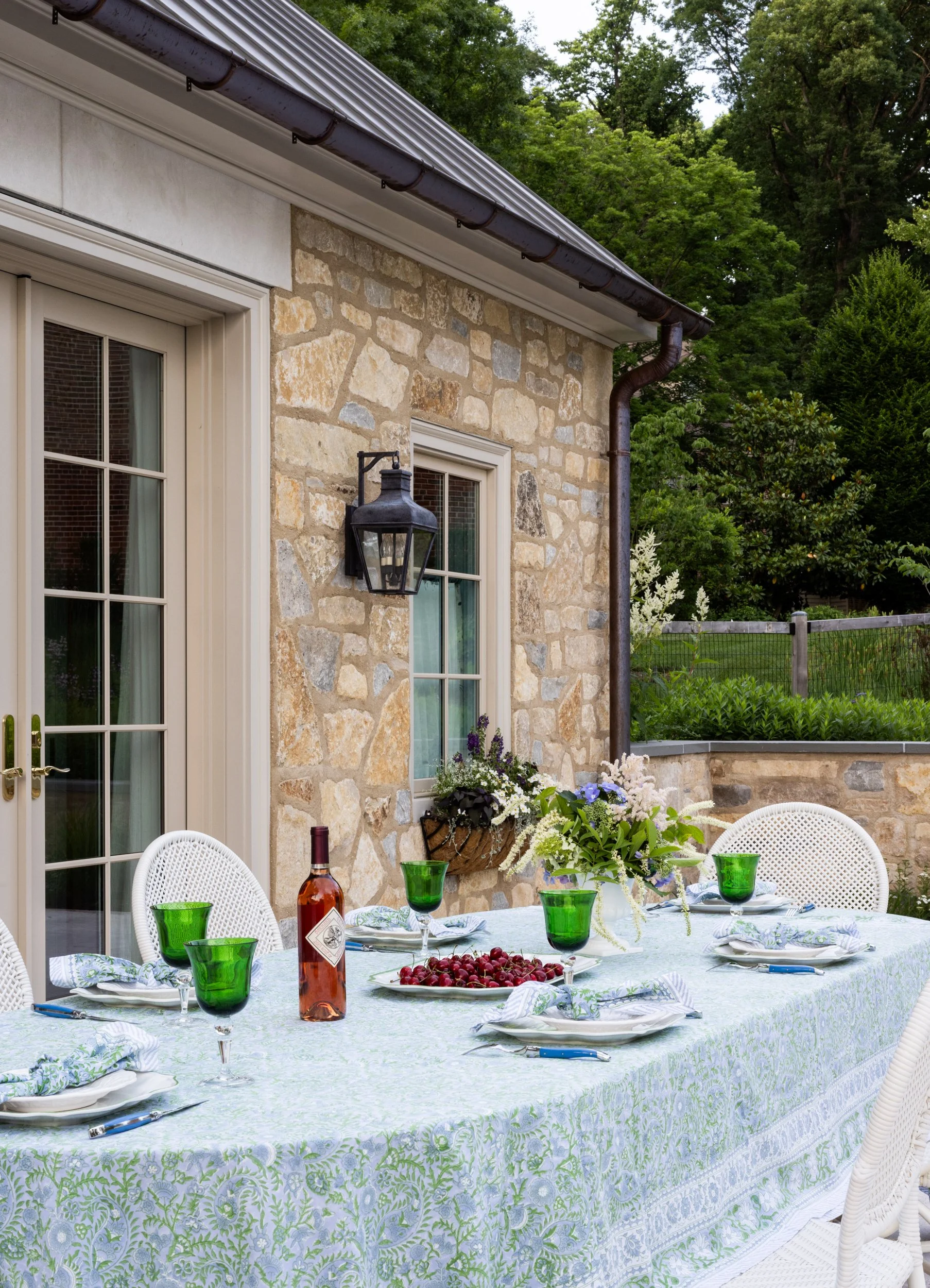 Outdoor stone dining patio with table setting by Raquel Langworthy