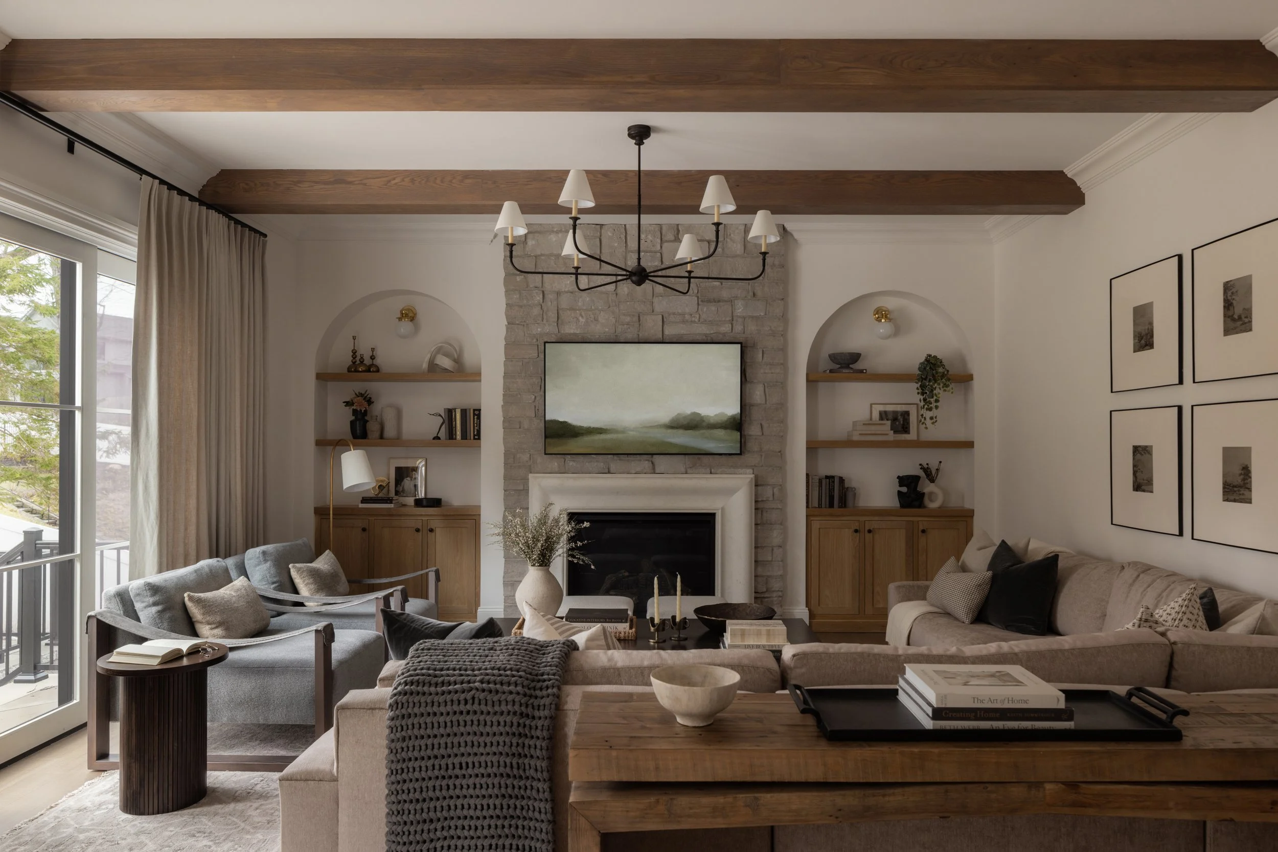A warm one-point perspective of a Short Hills, NJ family room featuring a stone fireplace and soft neutral textiles, featured in RUE Daily. Photographed by Raquel Langworthy.
