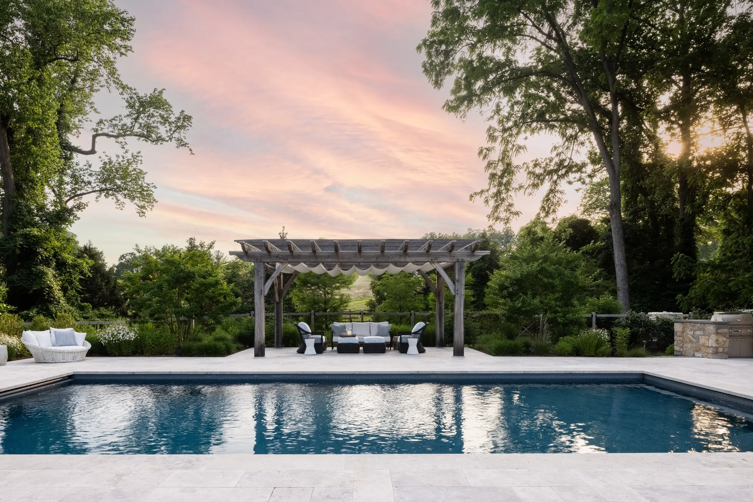 Outdoor pool with pergola at sunset by Raquel Langworthy
