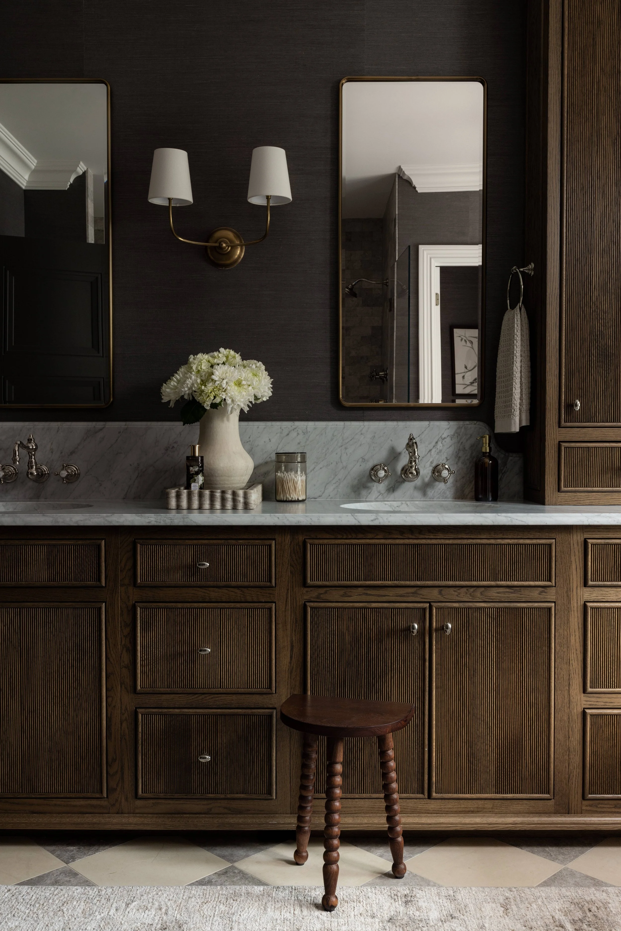 Dark moody bathroom with wood vanity by Raquel Langworthy