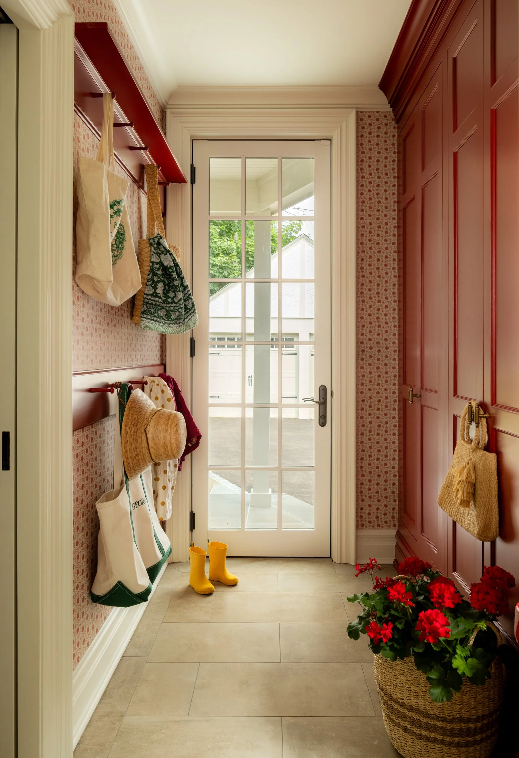 Mudroom entryway with red door and coat hooks by Raquel Langworthy
