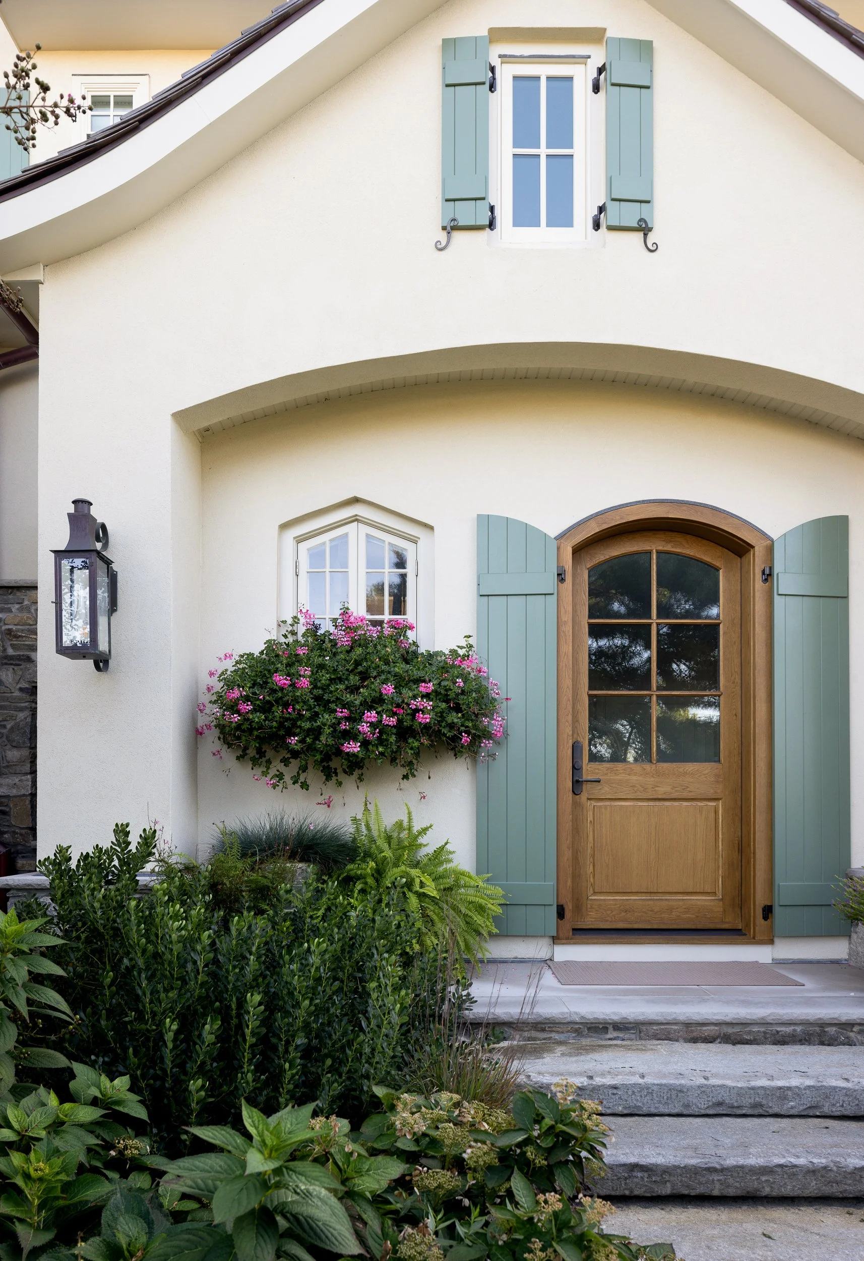 Charming cottage exterior with teal shutters and flower boxes by Raquel Langworthy