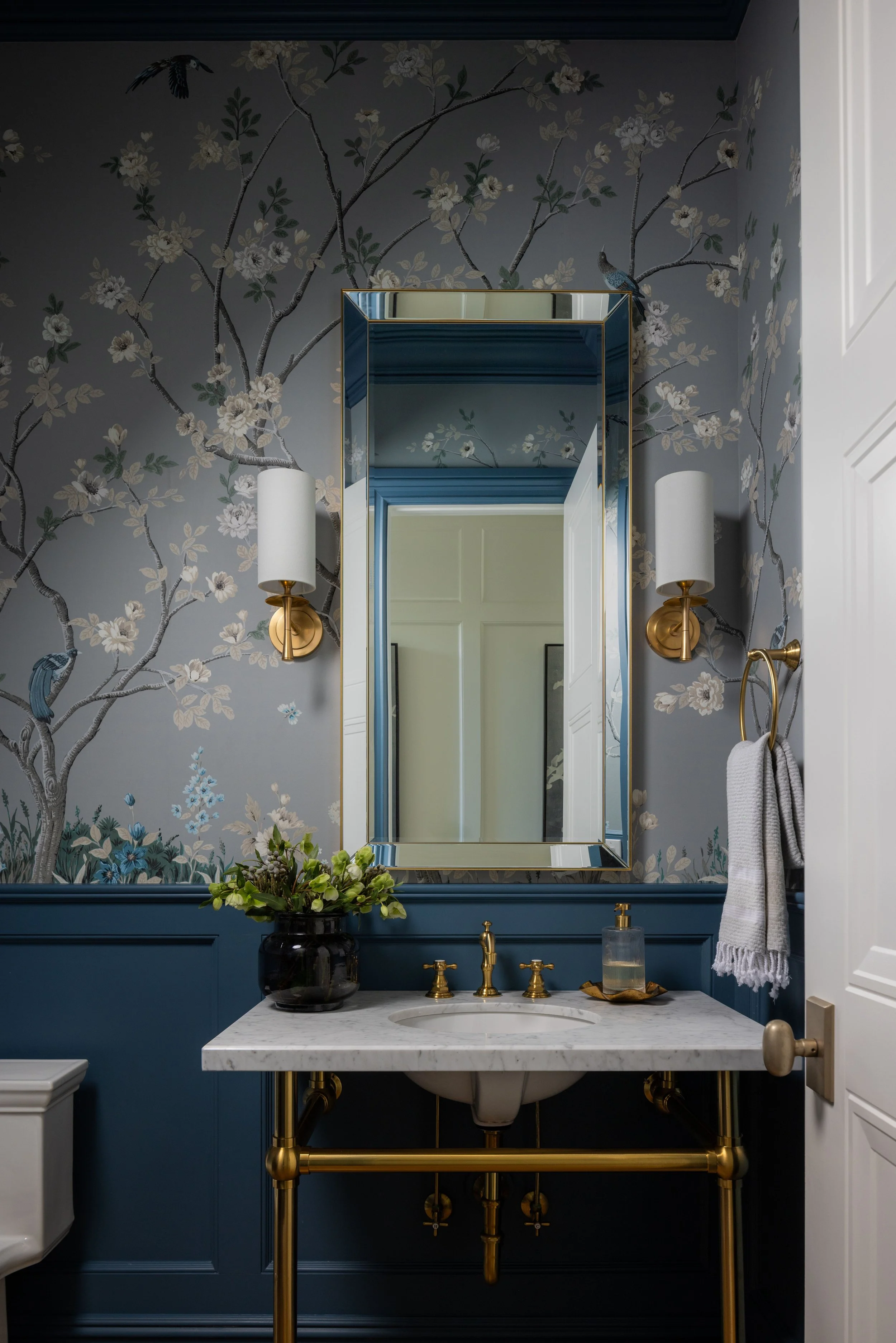 Blue grey bathroom with gold mirror and wall sconce by Raquel Langworthy