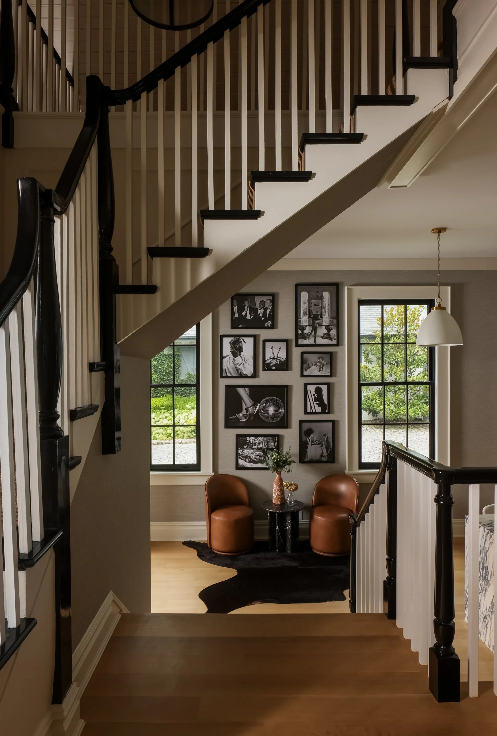 Staircase with gallery wall and black railing by Raquel Langworthy