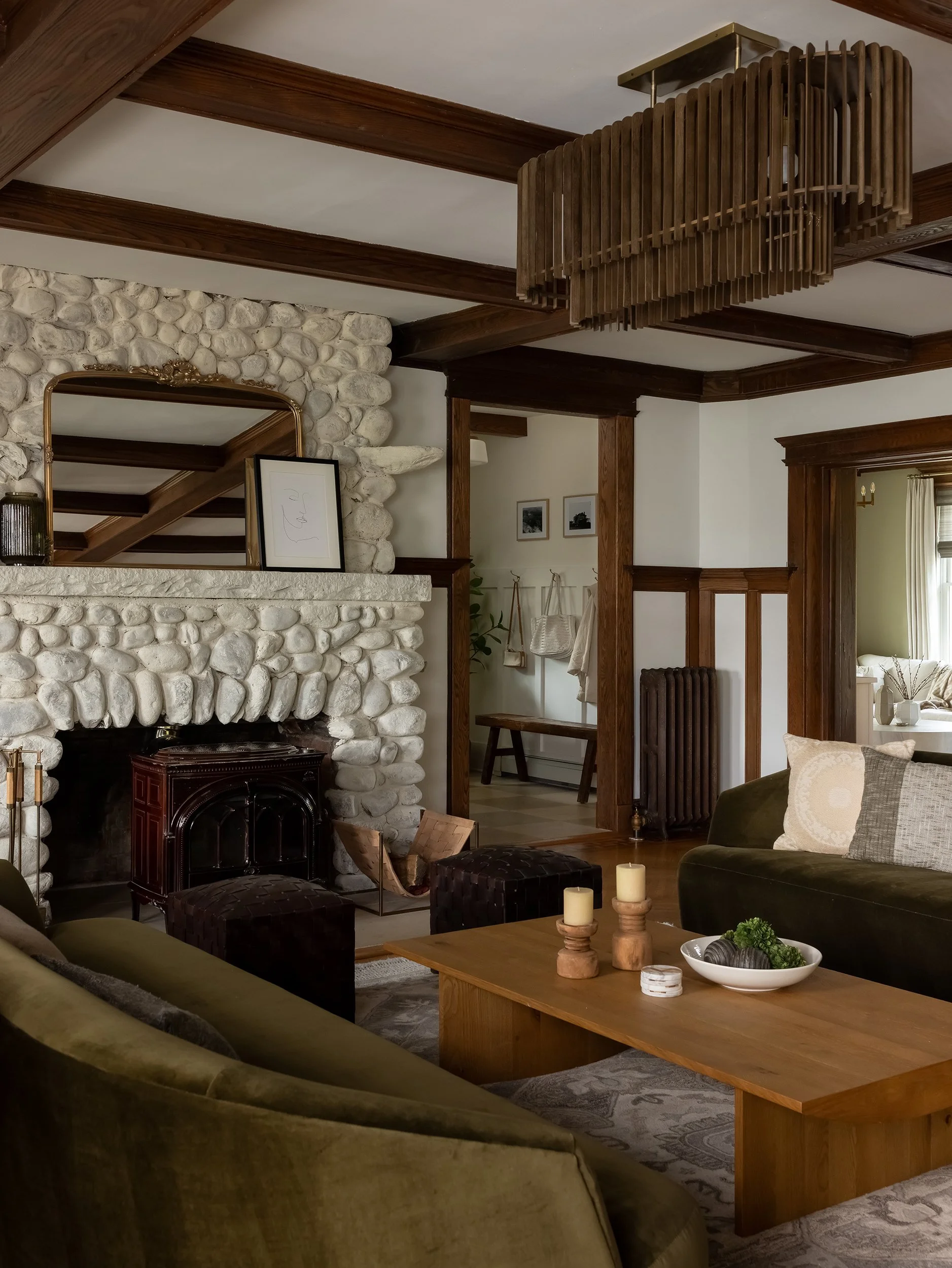 Rustic living room with stone fireplace and wood beams by Raquel Langworthy