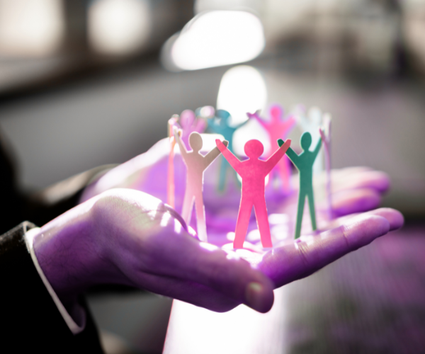 Photo of hand holding connected paper dolls