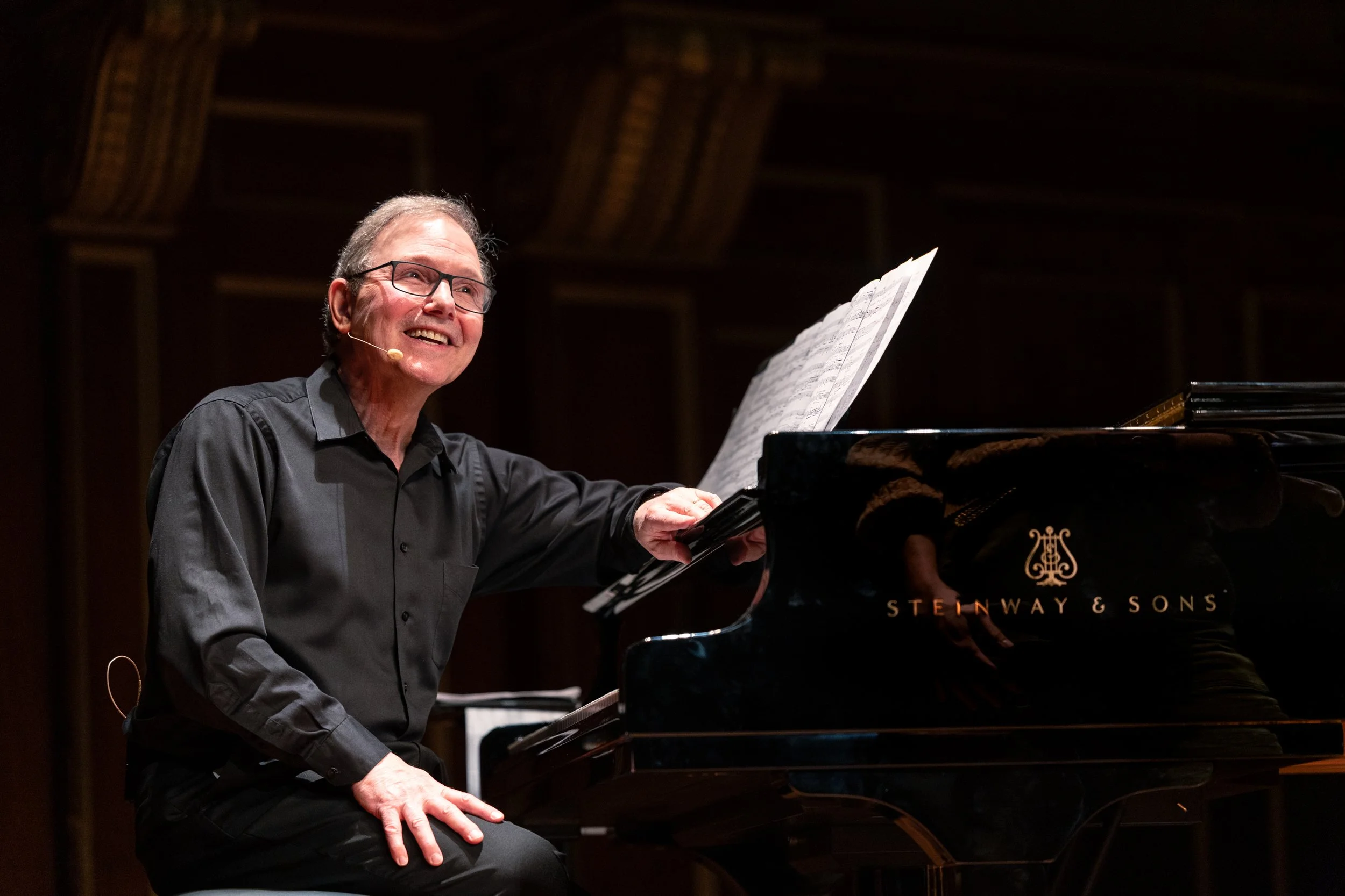 Composer, conductor, educator Rob Kapilow sits at the piano