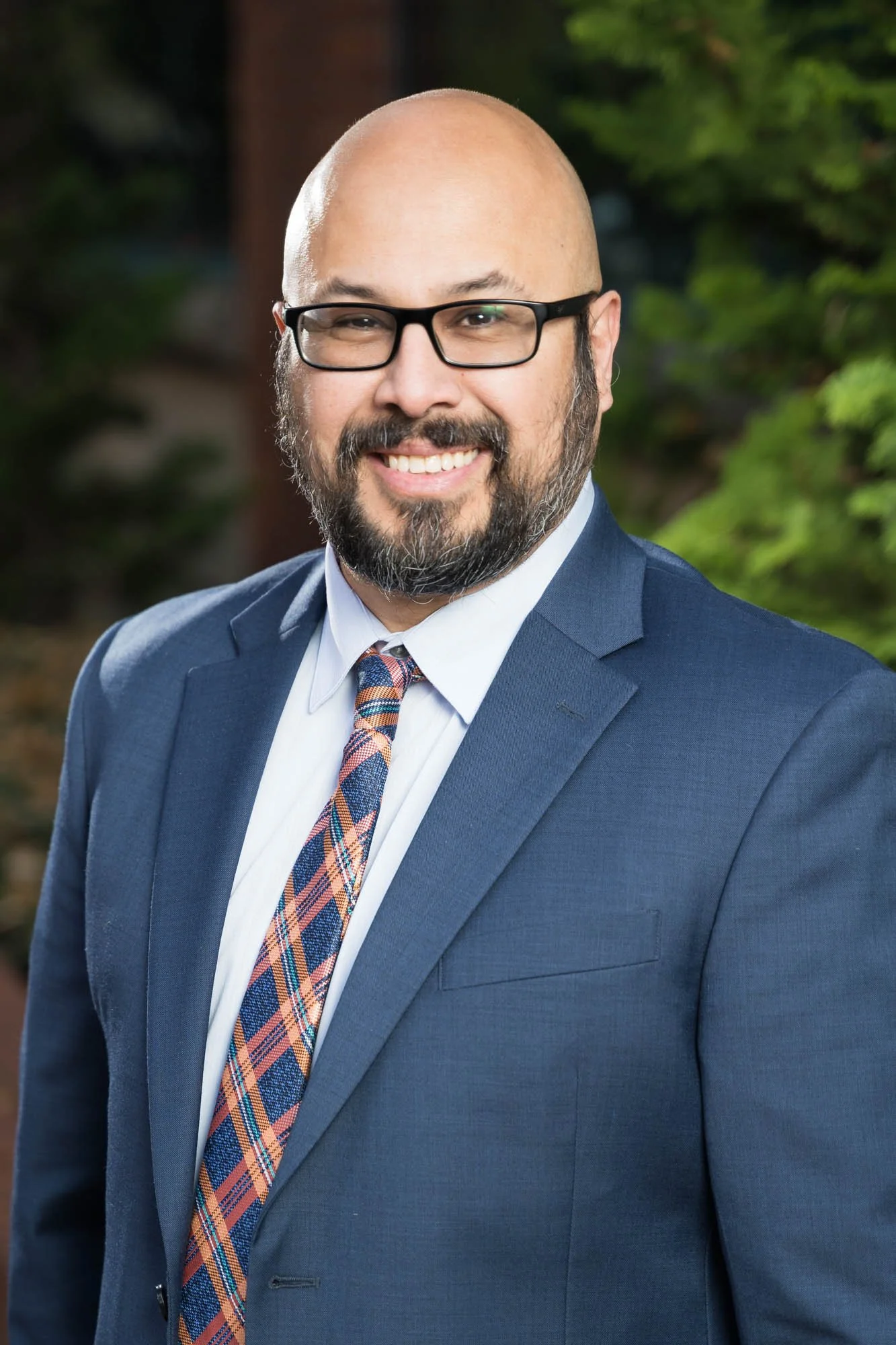 Professional headshot of a doctor in blue suit.