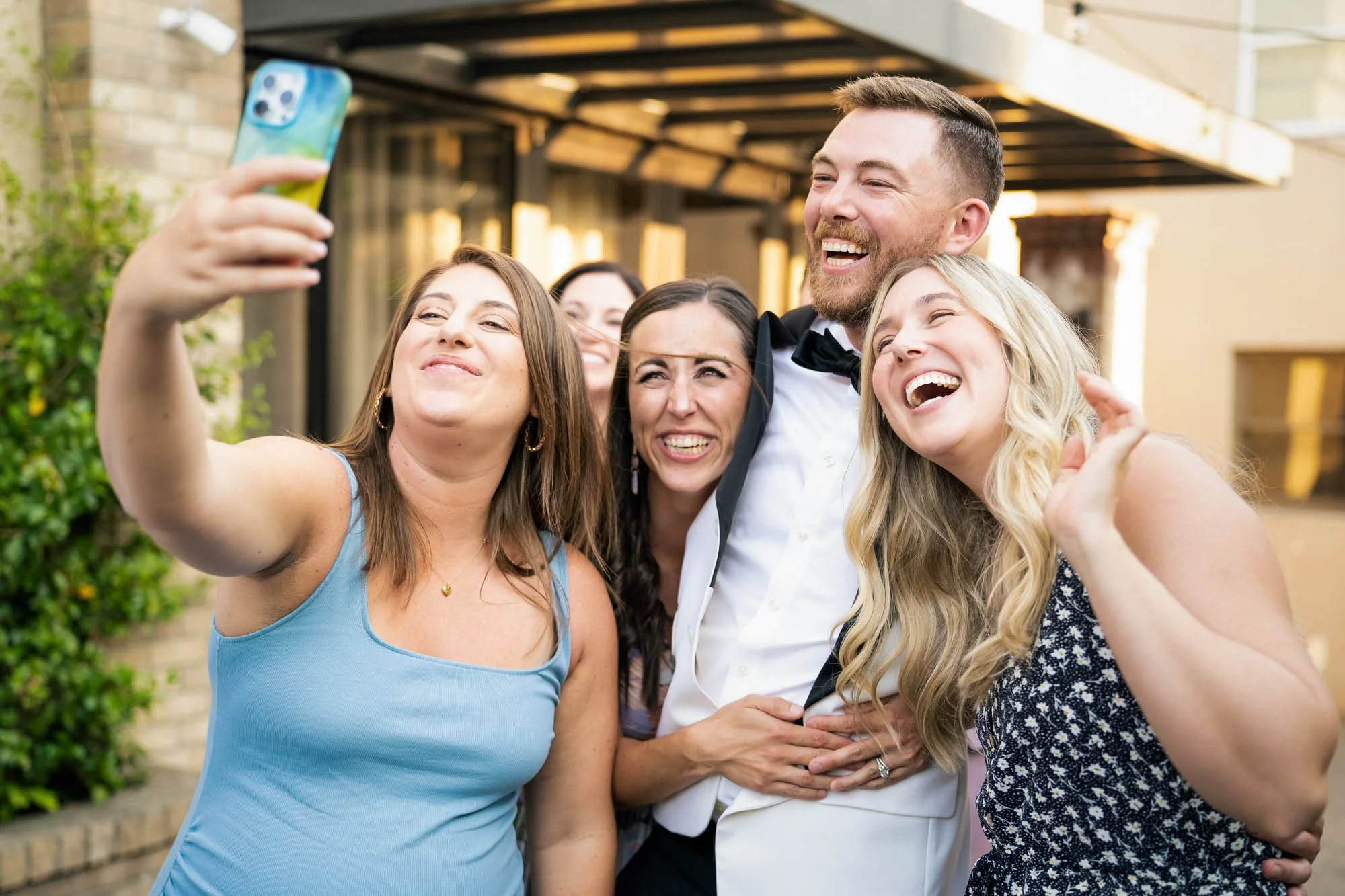Group of friends taking a selfie at a celebration or wedding outdoors, with smiles and happy expressions at Abernethy Center Veiled Garden and Ballroom.