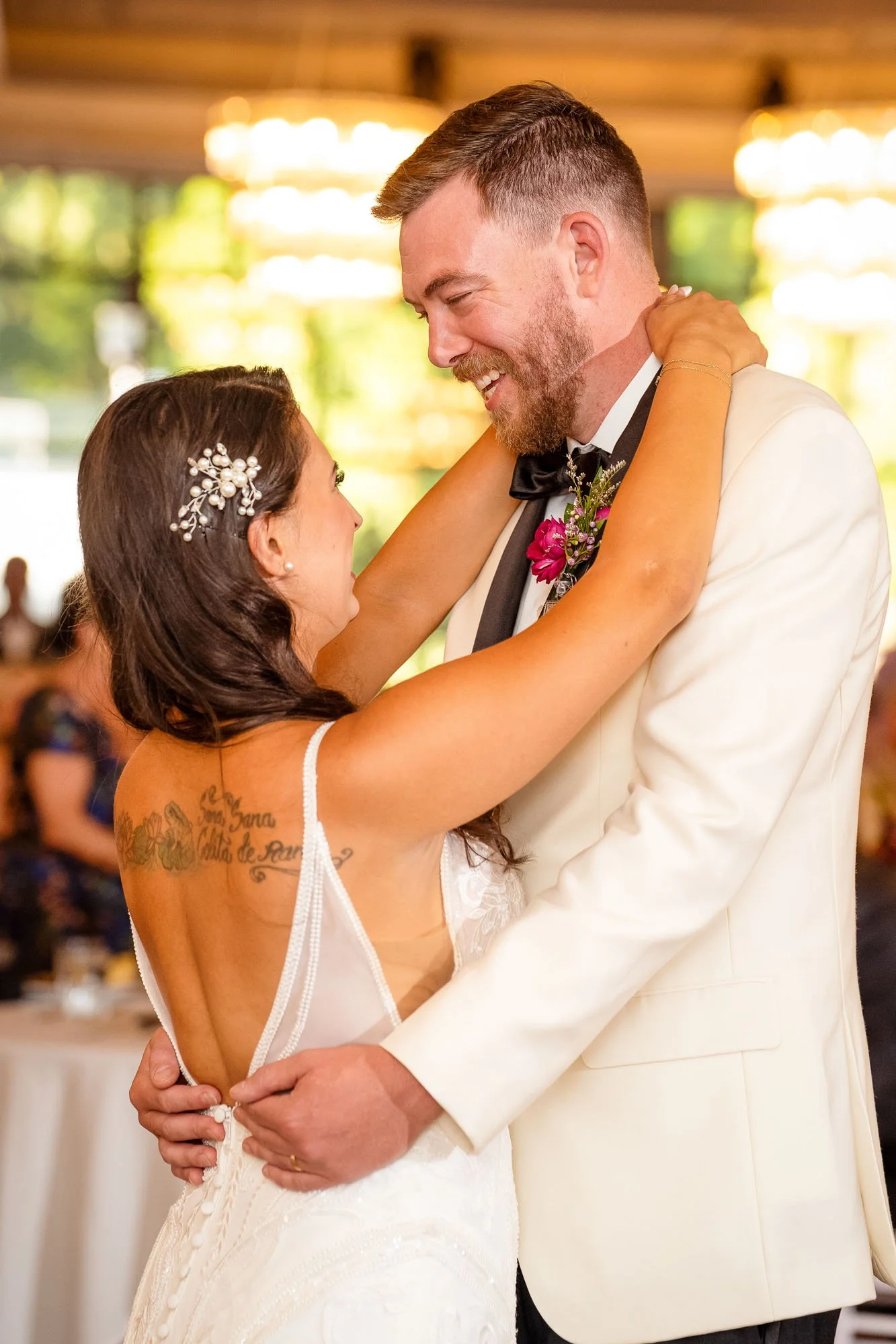 A bride and groom dance together at their wedding reception indoors, smiling and looking at each other in Abernethy Center VEILED GARDEN AND BALLROOM.