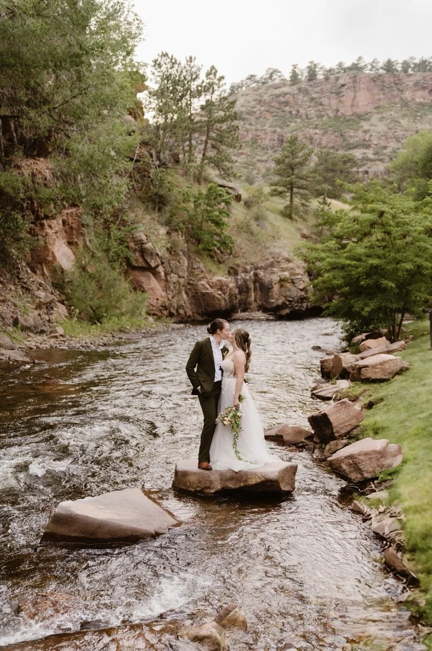 Gay couple sharing a kiss on a rock in the river