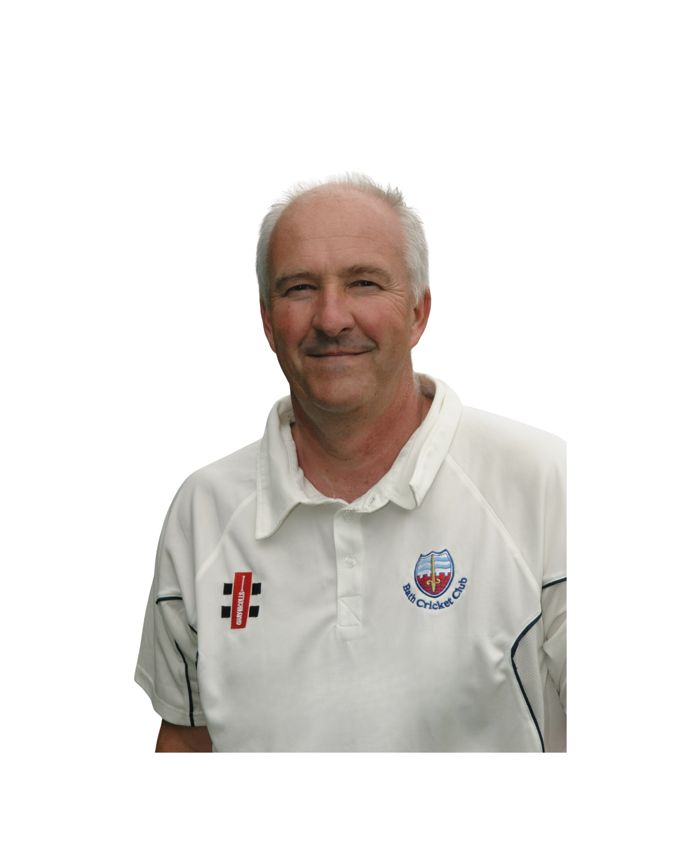 A man in a white cricket uniform smiling at the camera. The uniform has logos, including one for Beth Cricket Club, on the chest.