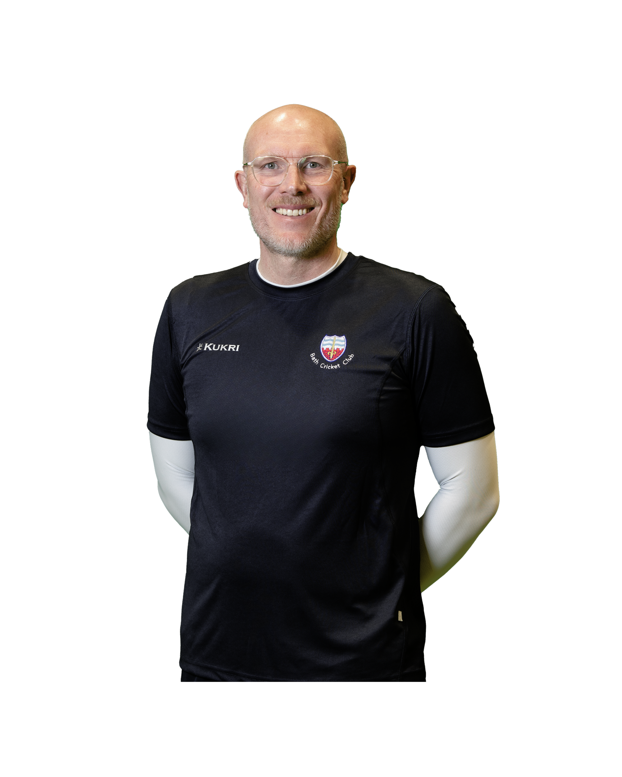 Smiling man wearing glasses and a black sports shirt with a logo and the text 'Bath Cricket Club'.