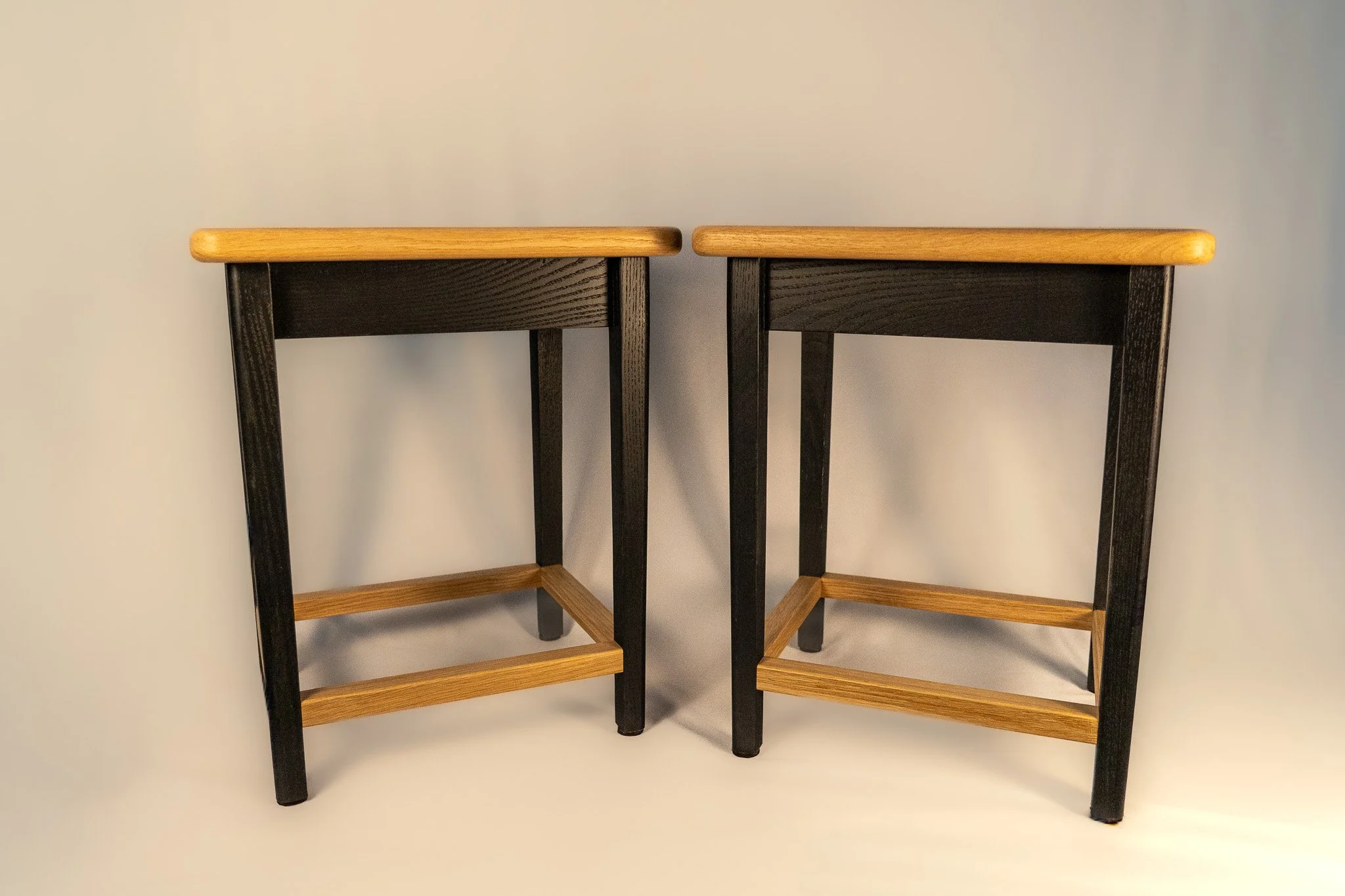 Matching end tables made from white oak, featuring stained black legs.