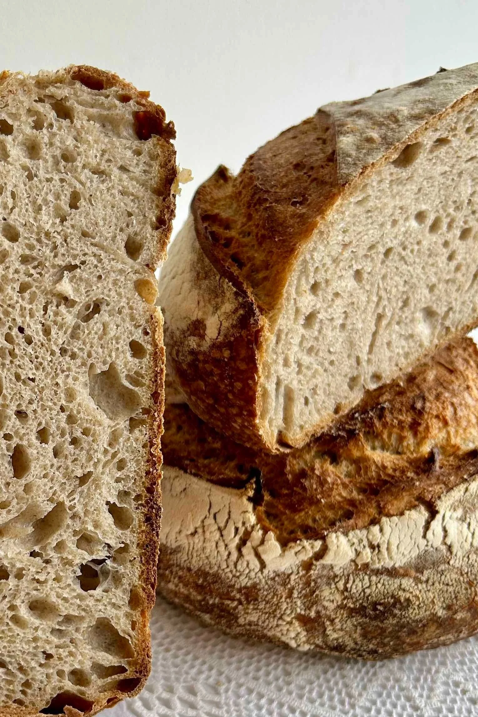 Close-up of sliced artisanal sourdough bread with a crusty exterior and airy interior.
