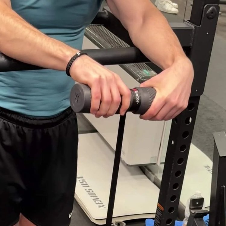 Athlete bracing his forearms on a bar while using the wrist roller