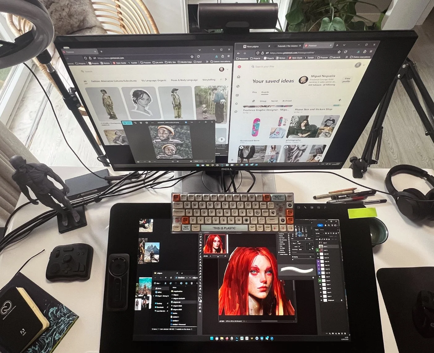 a beautiful shot of a concept artist workspace, showcasing anatomy figures, a professional digital drawing tablet, and colorful keyboard