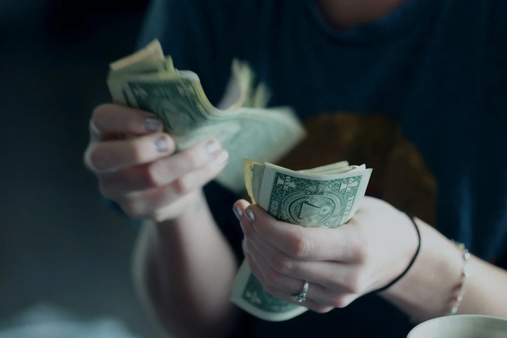 hands counting dollar bills