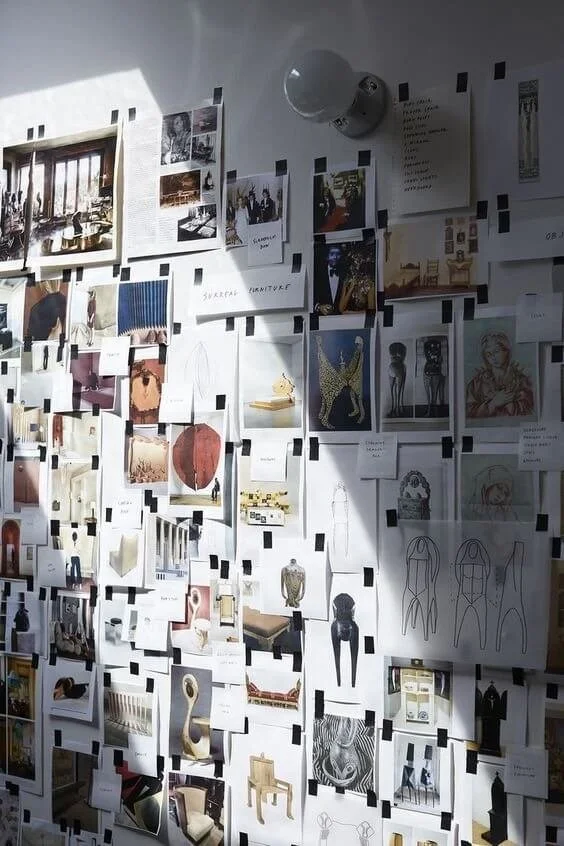 a beautiful shot of a few photographs and illustrations pinned on a wall, illustrating the thought process and research that it takes to execute great character design for games and film