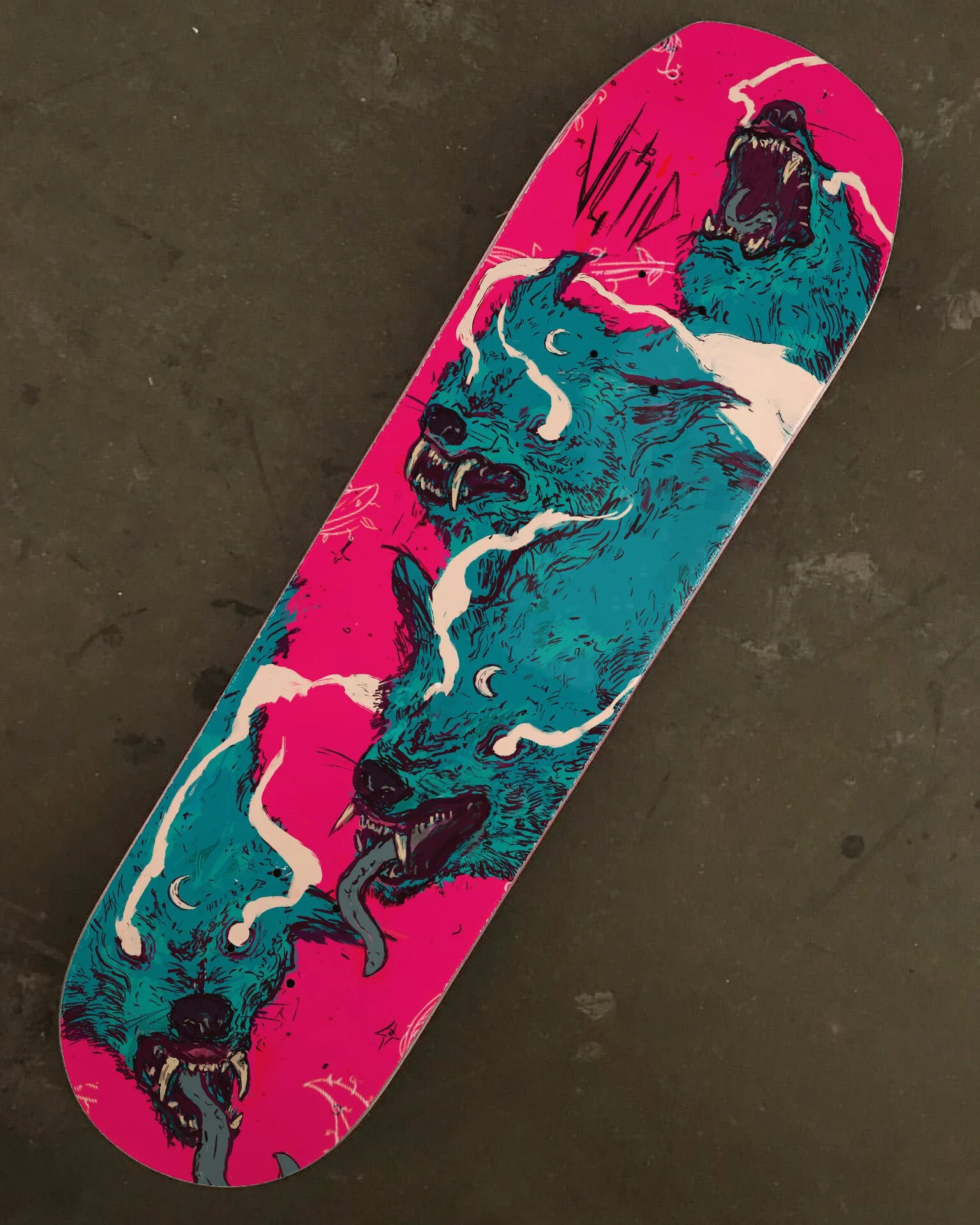 A skateboard deck with colorful artwork of three snarling wolf heads and lightning bolts on a pink background.