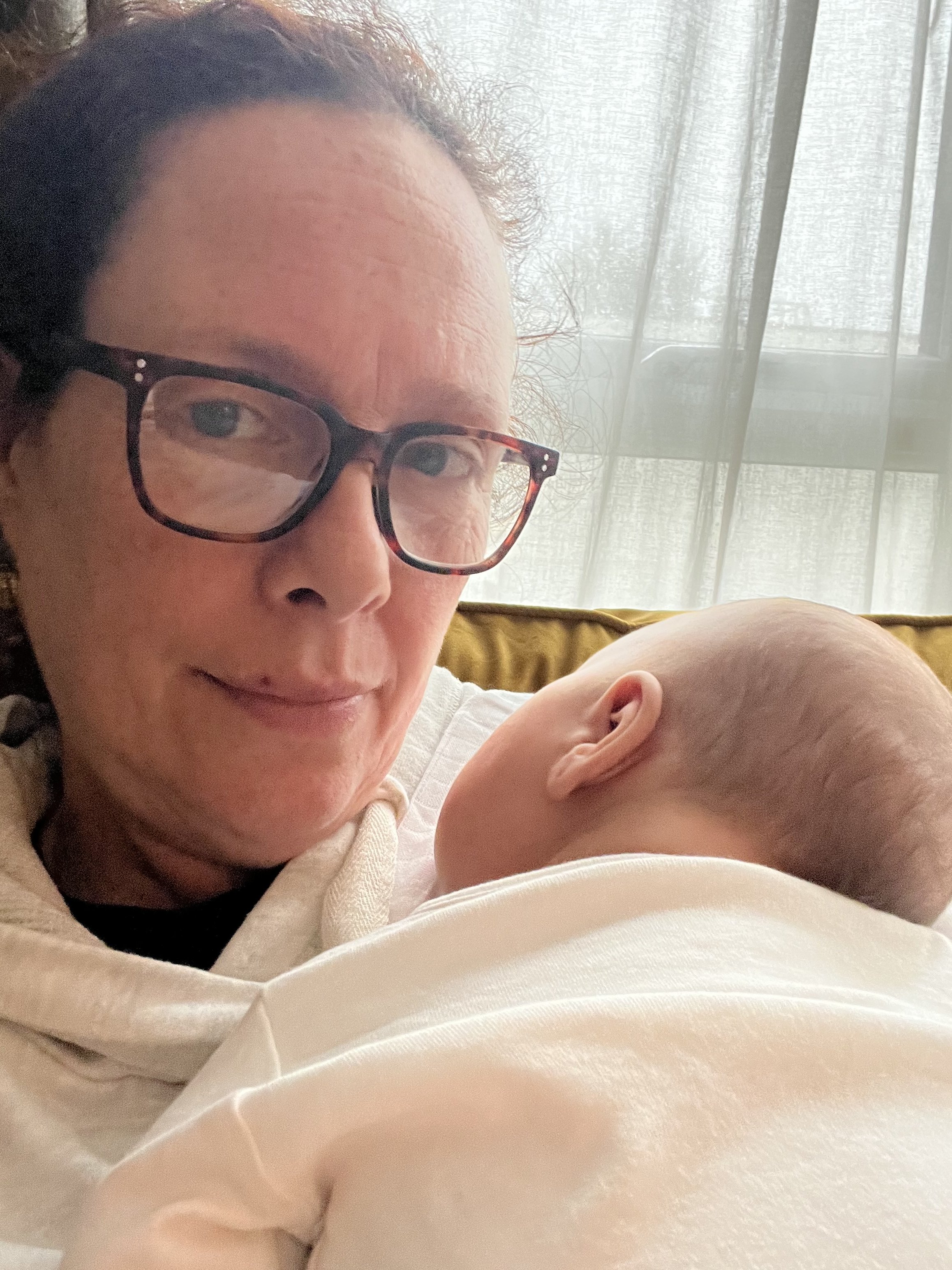 Zoe Sylvester holding a newborn baby while providing overnight postnatal support to a family.