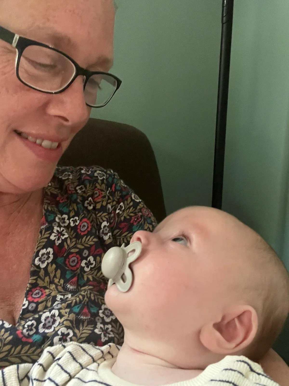Zoe Sylvester cuddling a newborn baby while supporting a family after birth.