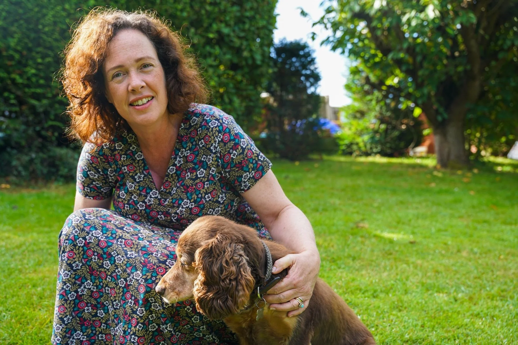 Portrait of Zoe Sylvester, founder of Ma Doula, smiling outdoors with her dog.