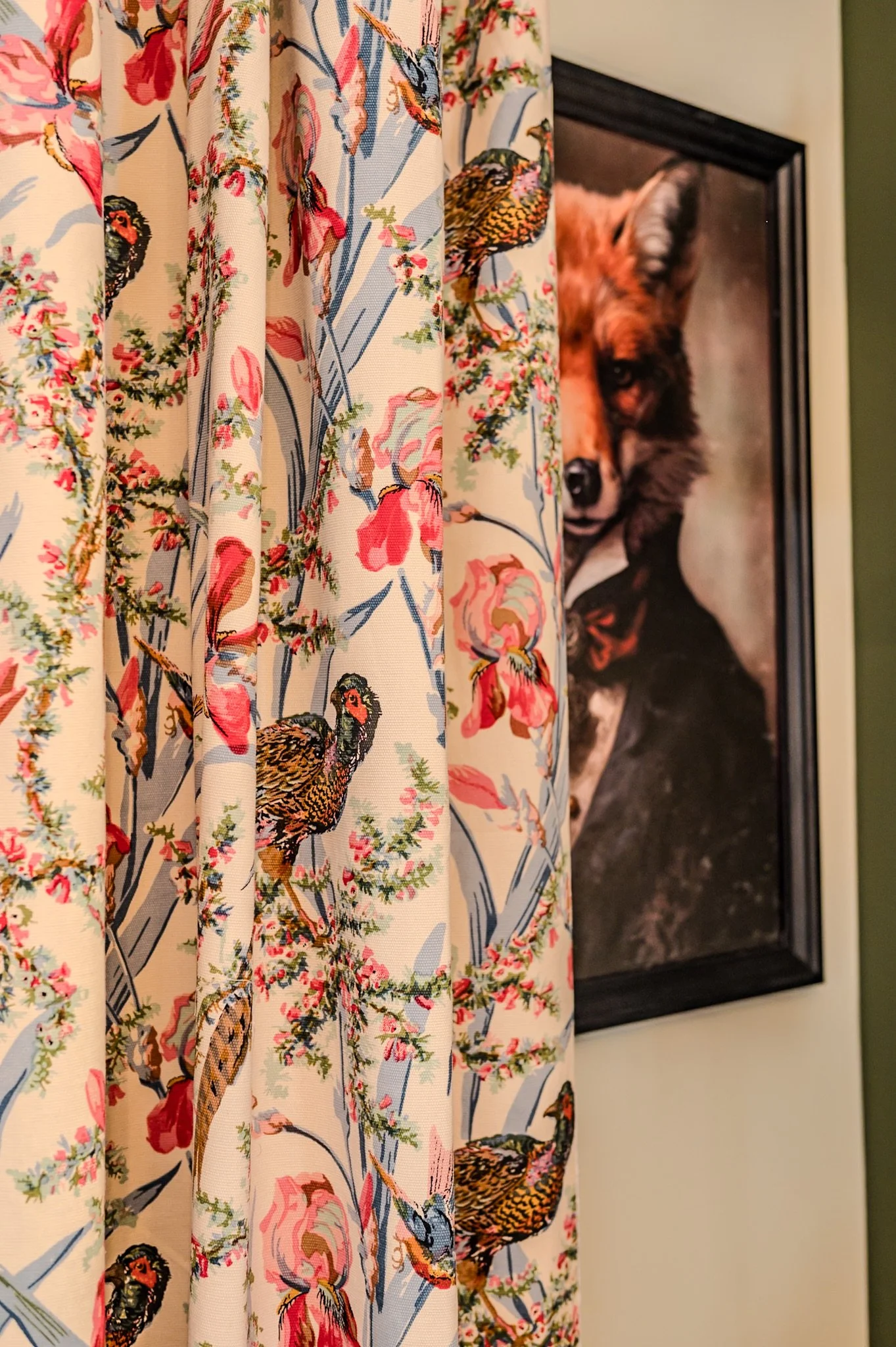 Badetuch mit Vogel- und Blumenmuster hängt vor einem Wandbild eines Hundes.