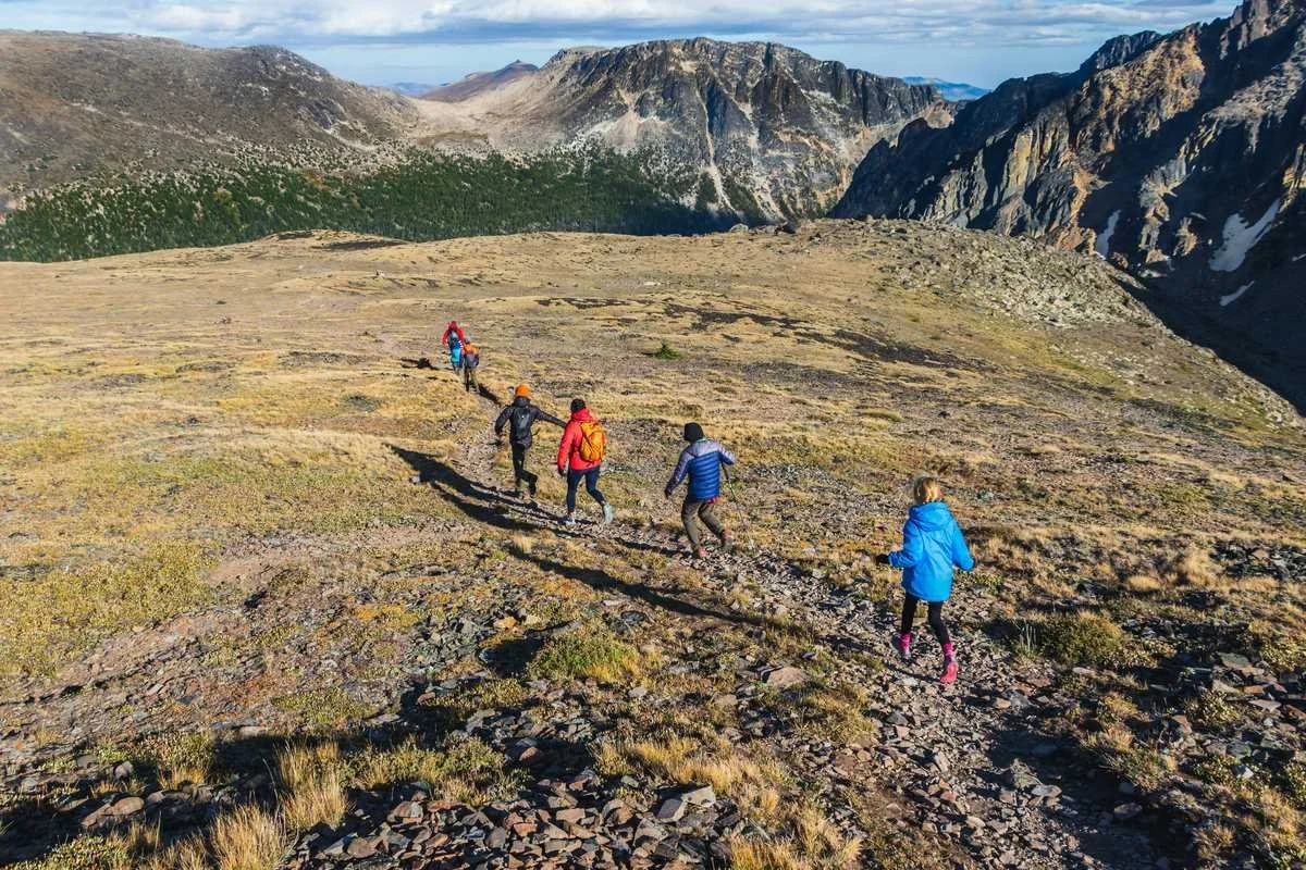 Group of hikers walking uphill through mountain landscape — active lifestyle and movement as daily habit are key drivers of healthspan.