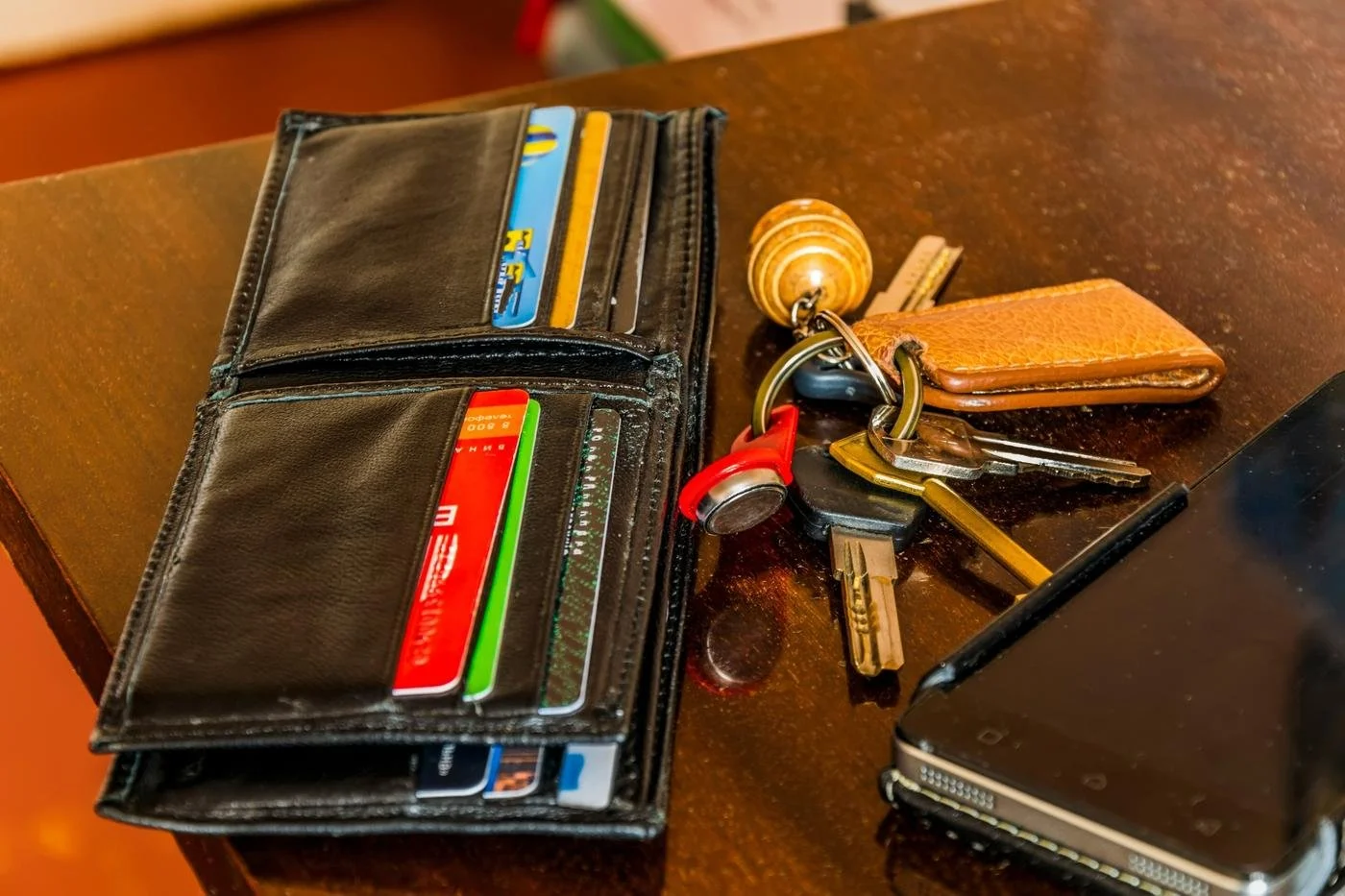 Open wallet with credit cards and keys on a counter, symbolizing everyday spending decisions and the 0.01% rule.