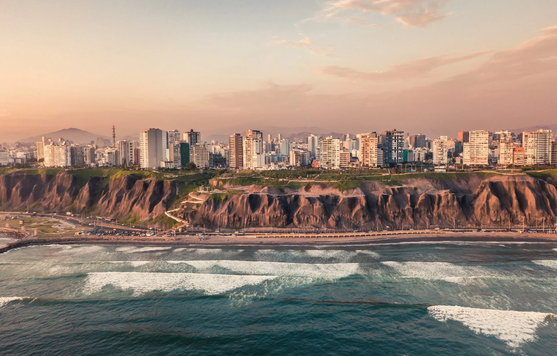 Aerial view of Lima, Peru's Miraflores coastline and cliffs at sunset, the city with the most comfortable outdoor hours of 478 studied.