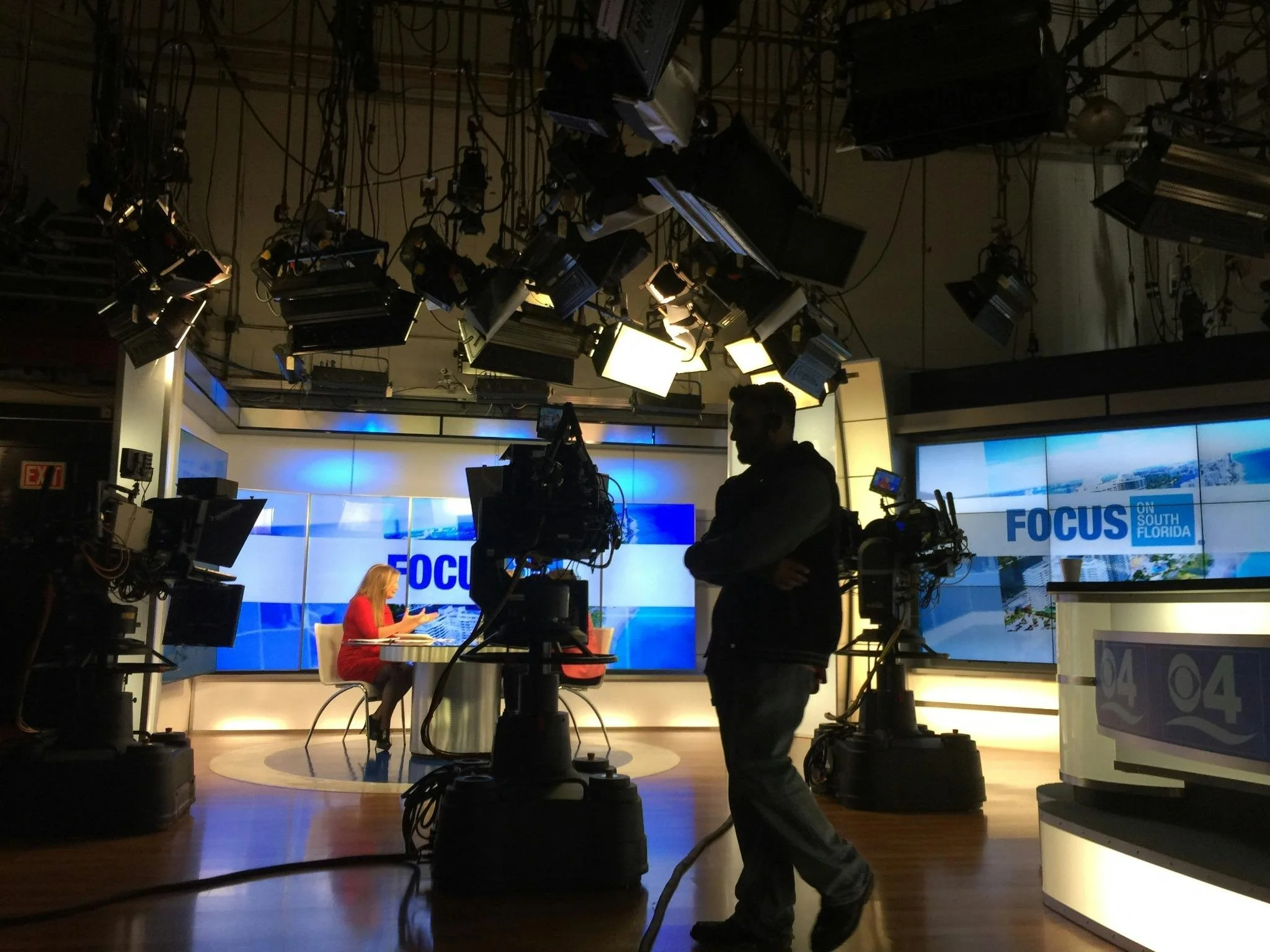 Television news studio with cameras and lighting, representing attention-driven media and negative news incentives.