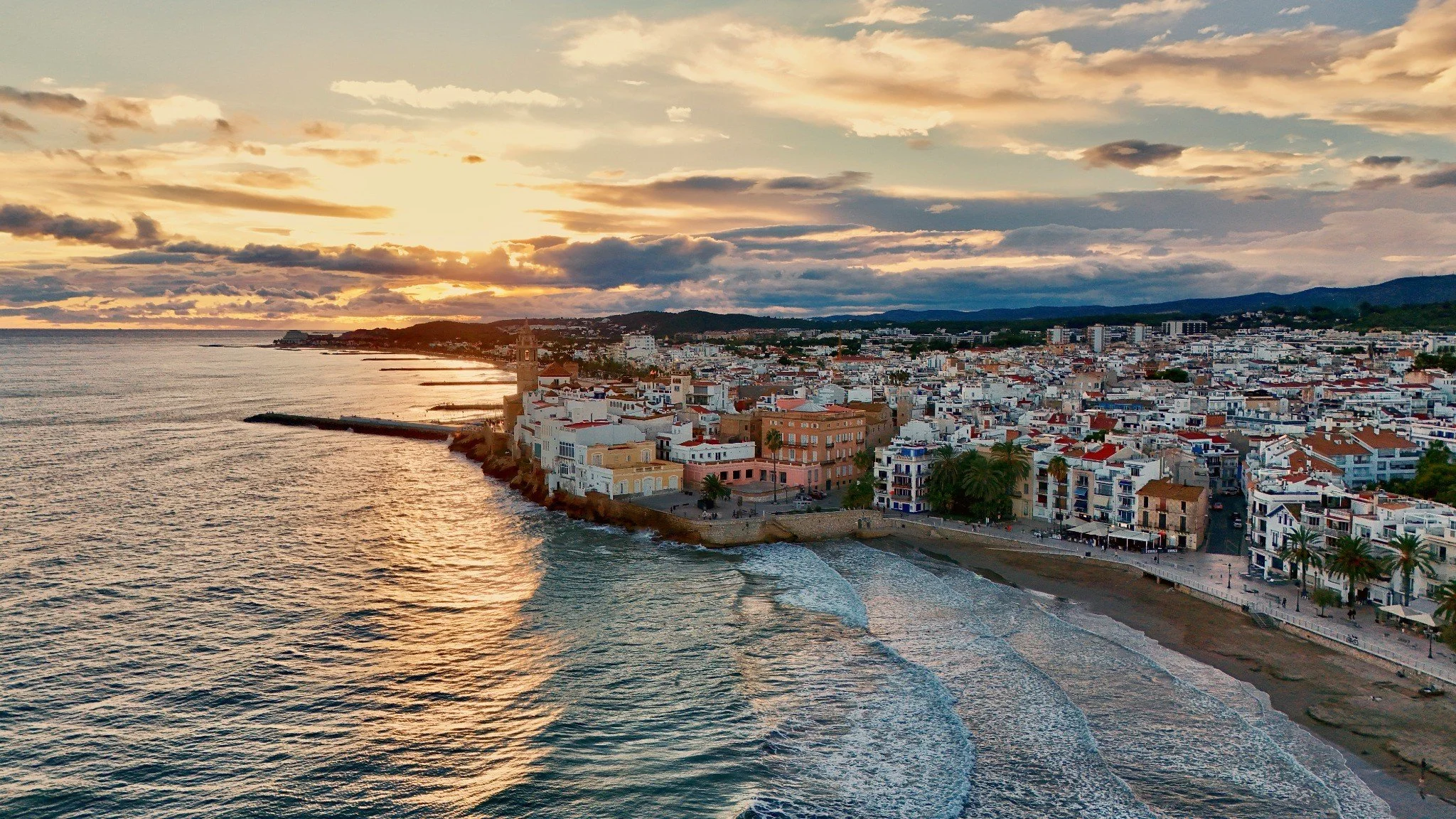 Sitges Spain beach at sunset showing Mediterranean coastal lifestyle and mild climate—symbolizing Europe’s best retirement destinations under climate change.