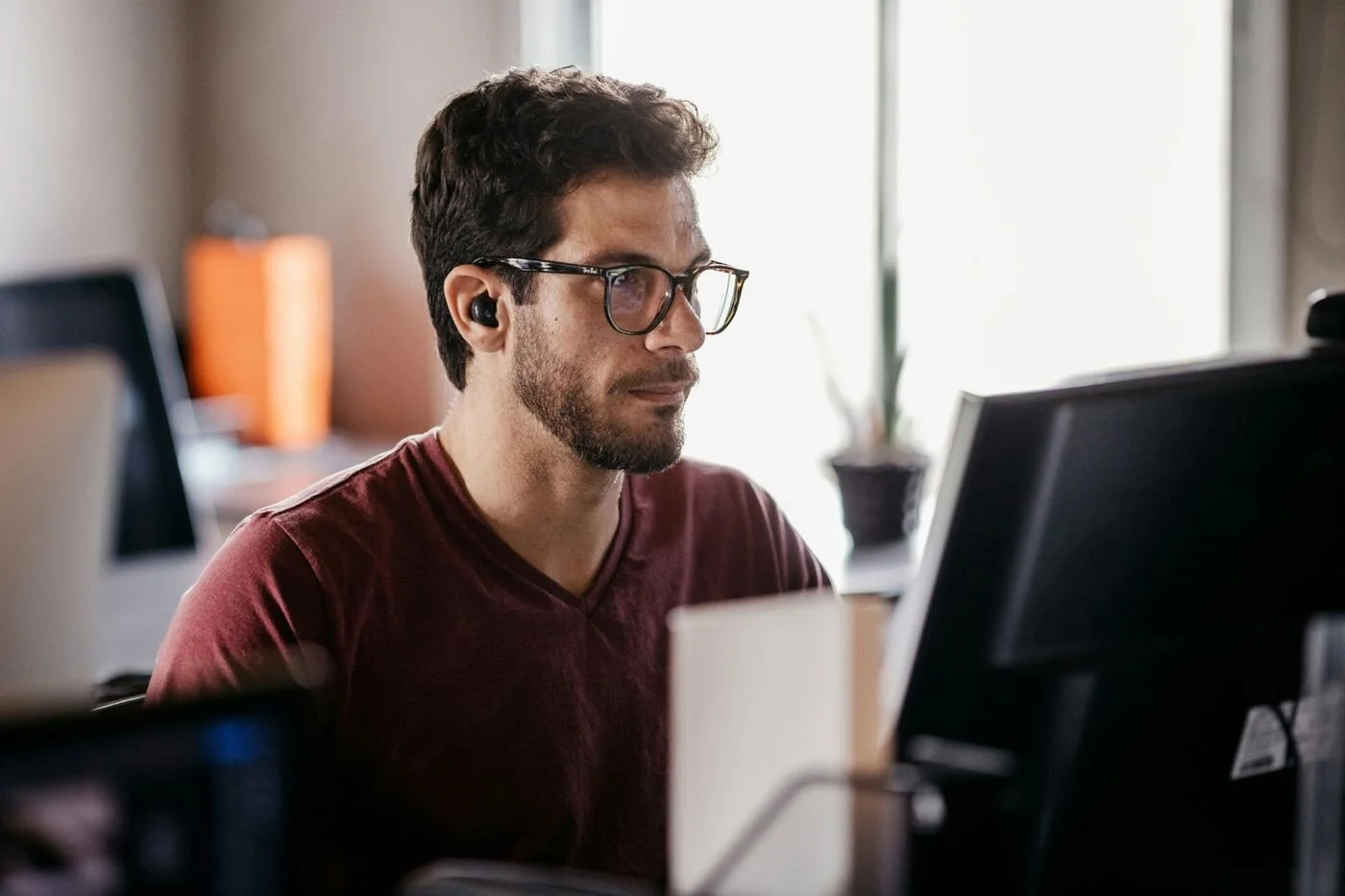 Man at a computer desk looking focused — representing the behavioural discipline required to stay invested through market volatility.