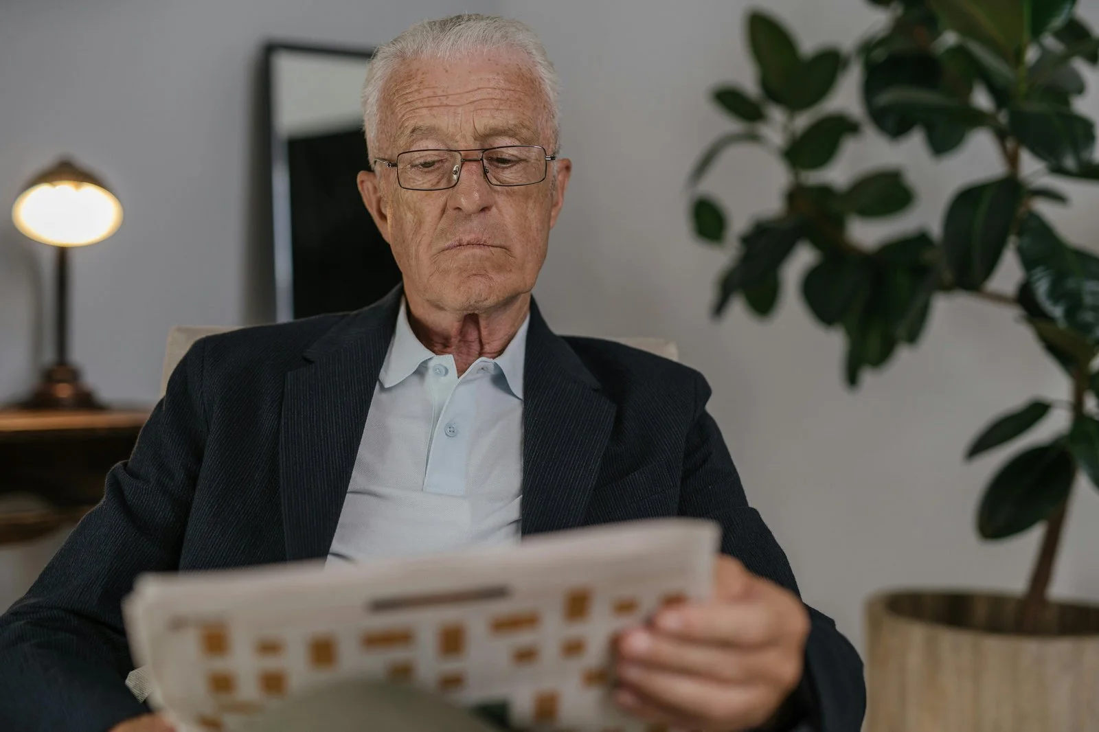 Senior investor reading financial newspaper — representing the traditional appeal of dividend investing and the era when it made more sense.