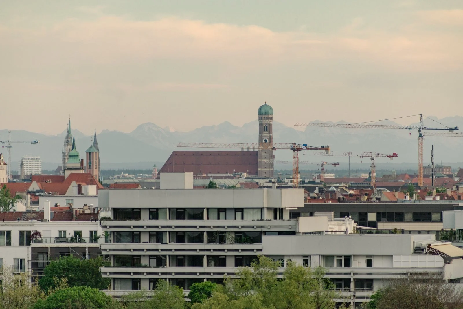 Munich skyline with the Frauenkirche towers and the snow-capped Alps behind, Germany.